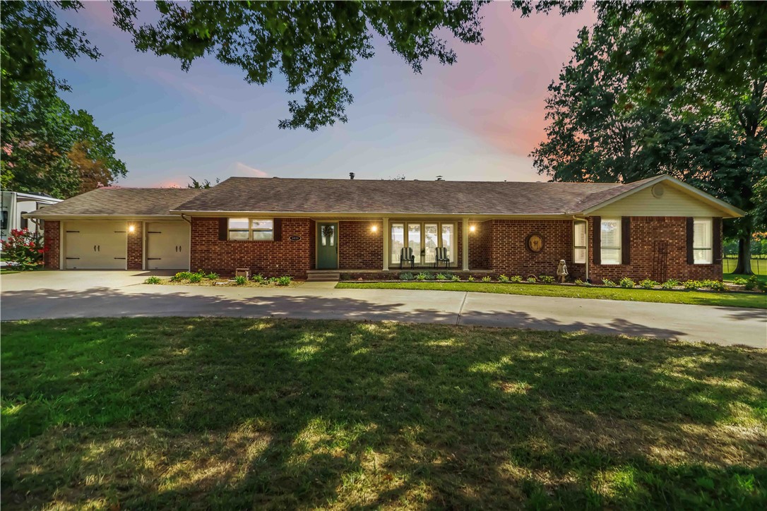 This charming ranch-style home exudes classy character with a warm, inviting feel throughout. Offering 3 bedrooms and 2.5 baths, the layout is both comfortable and functional. A convenient half bath located off the back of the home is perfectly positioned to serve the impressive 1,888-square-foot shop, which features a finished-out space ideal for a home-based business, rental income, or creative hobbies, along with ample storage. Conveniently located in central Northwest Arkansas with easy access to Highway 71 Business and I-49, this property combines accessibility with space to spread out. Situated on just over an acre of flat, level land, this home offers endless possibilities and is ready for you to make it your own.