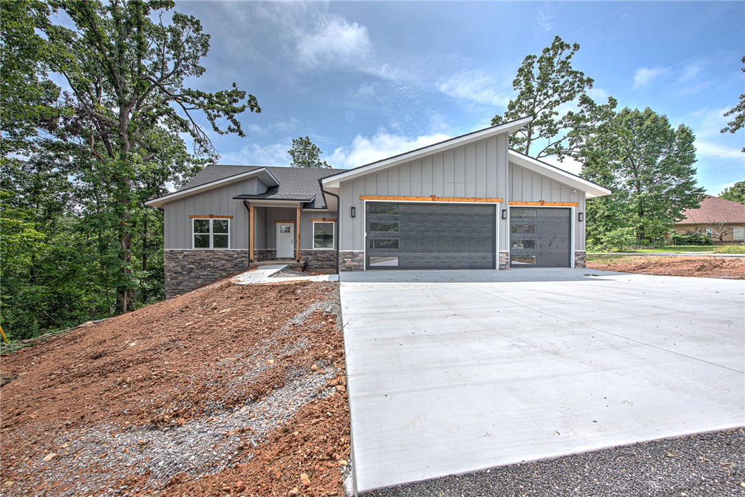 If you’ve been searching for something beyond the average new construction home in Bella Vista, this is it. Perfectly positioned on a corner lot directly on Tunnel Vision Trail with nearby trailhead access just moments away, this 3-bedroom, 2-bath home with dedicated office was designed for those who value both elevated living and outdoor adventure. Offering 1,929 sq ft of thoughtfully curated space, the home blends modern mountain-inspired design with quality craftsmanship and attention to detail rarely found in typical new construction. The striking exterior, oversized 3-car garage, and wooded surroundings create an immediate sense of privacy and character, while the location places world-class biking and walking trails literally in your backyard. Whether you're an avid cyclist, nature lover, or simply looking for a home with more style, function, and personality, 2 Grier Lane delivers a lifestyle that stands apart. See List of Upgrades for additional features and enhancements throughout the home.