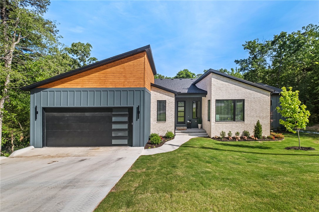 Modern design meets wooded serenity in this stunning new-construction home. Clean lines, designer exterior finishes, and expansive windows create a bright, contemporary feel throughout. A sleek entry, open layout, and elevated architectural details set this home apart. Enjoy seamless indoor–outdoor living with a large covered deck and spacious lower patio overlooking the trees—perfect for relaxing or entertaining. A rare Bella Vista find offering privacy, style, and quality craftsmanship in a peaceful setting. Builder includes a 1-year warranty, and Approved borrowers will receive a closing cost credit of 1% of loan amount up to $5000 on their Closing Disclosure on their loan with Preferred Lender.