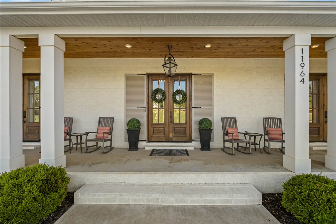 Tucked behind the gated entrance of Long Acres, this exceptional custom home blends luxury, comfort and functionality on a beautifully landscaped setting near XNA and all Northwest Arkansas has to offer. Thoughtfully designed with upscale finishes throughout, the home features quartz countertops, custom trim work, designer lighting, and an oversized refrigerator/freezer anchoring the stunning chef’s kitchen. Spacious living areas are complemented by two gas fireplaces creating warm and inviting spaces for entertaining or everyday living. The walkout basement offers incredible flexibility for additional living, recreation or guest space. Enjoy year-round outdoor living on the covered back porch complete with infrared heaters and scenic surroundings. Additional highlights include natural gas, an electric vehicle outlet, and extensive custom landscaping that enhances curb appeal and privacy. A rare combination of elegance, modern convenience, and timeless craftsmanship in one of Bentonville’s most desirable locations.