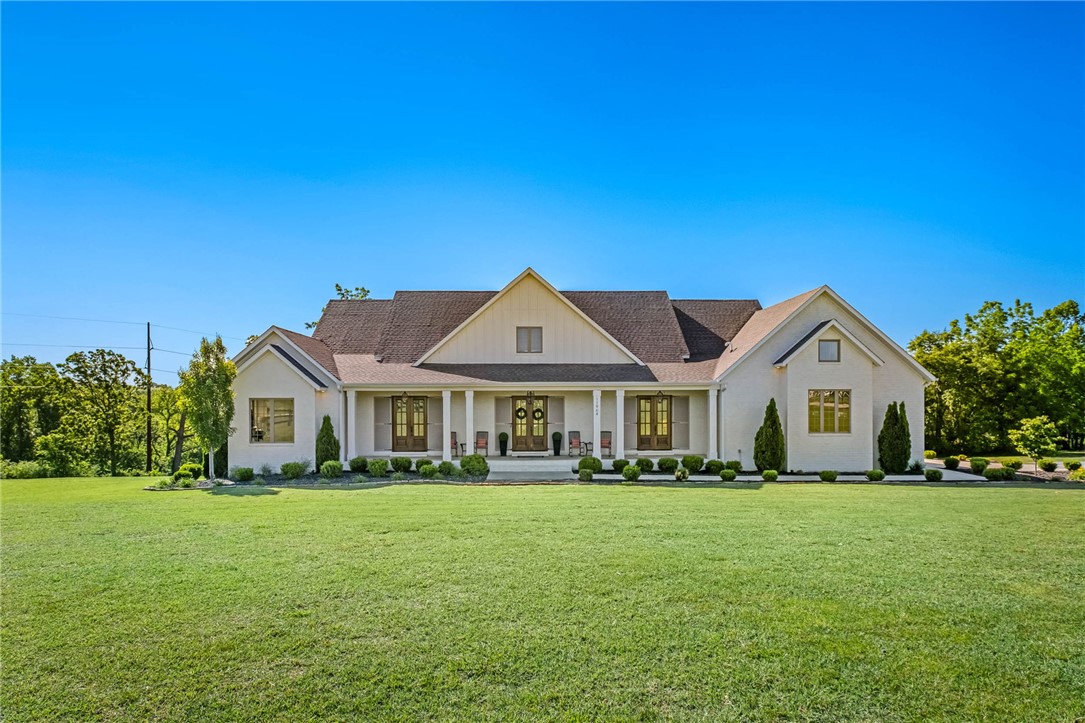 Tucked behind the gated entrance of Long Acres, this exceptional custom home blends luxury, comfort and functionality on a beautifully landscaped setting near XNA and all Northwest Arkansas has to offer. Thoughtfully designed with upscale finishes throughout, the home features quartz countertops, custom trim work, designer lighting, and an oversized refrigerator/freezer anchoring the stunning chef’s kitchen. Spacious living areas are complemented by two gas fireplaces creating warm and inviting spaces for entertaining or everyday living. The walkout basement offers incredible flexibility for additional living, recreation or guest space. Enjoy year-round outdoor living on the covered back porch complete with infrared heaters and scenic surroundings. Additional highlights include natural gas, an electric vehicle outlet, and extensive custom landscaping that enhances curb appeal and privacy. A rare combination of elegance, modern convenience, and timeless craftsmanship in one of Bentonville’s most desirable locations.