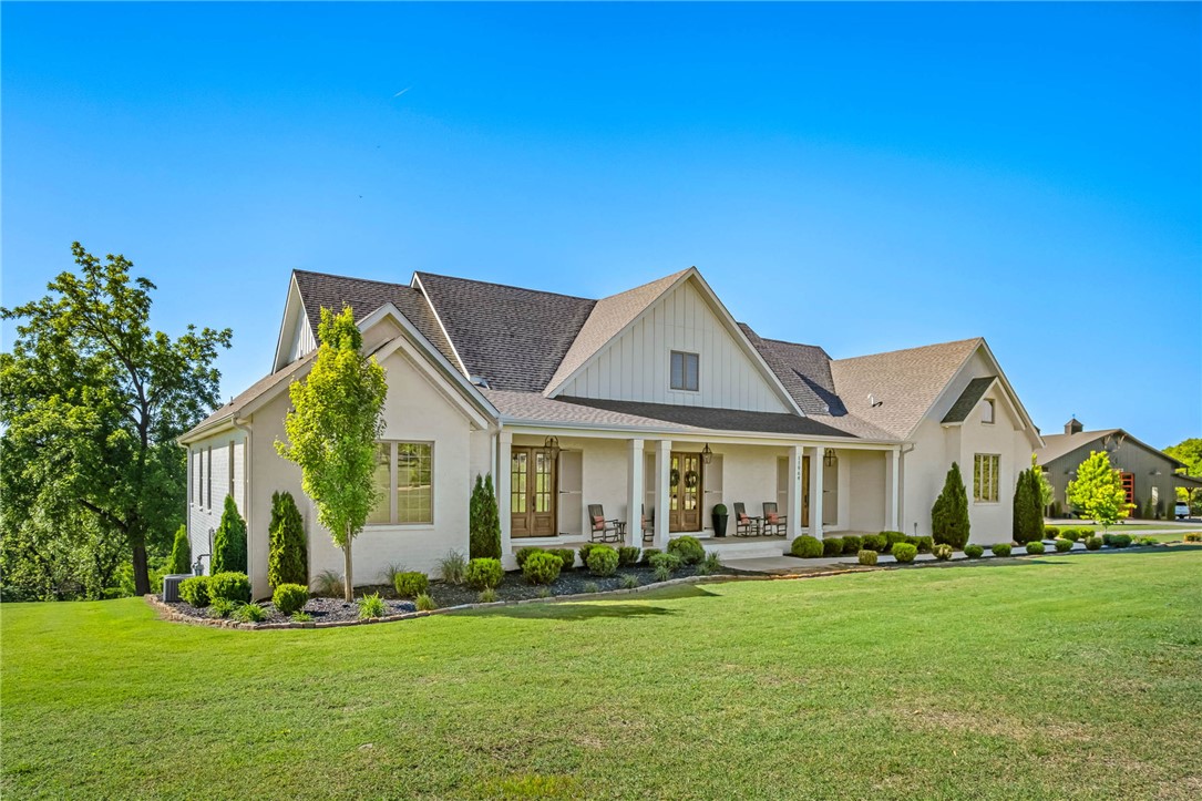 Tucked behind the gated entrance of Long Acres, this exceptional custom home blends luxury, comfort and functionality on a beautifully landscaped setting near XNA and all Northwest Arkansas has to offer. Thoughtfully designed with upscale finishes throughout, the home features quartz countertops, custom trim work, designer lighting, and an oversized refrigerator/freezer anchoring the stunning chef’s kitchen. Spacious living areas are complemented by two gas fireplaces creating warm and inviting spaces for entertaining or everyday living. The walkout basement offers incredible flexibility for additional living, recreation or guest space. Enjoy year-round outdoor living on the covered back porch complete with infrared heaters and scenic surroundings. Additional highlights include natural gas, an electric vehicle outlet, and extensive custom landscaping that enhances curb appeal and privacy. A rare combination of elegance, modern convenience, and timeless craftsmanship in one of Bentonville’s most desirable locations.