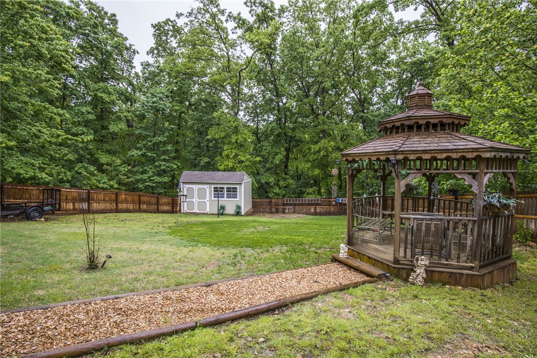 BEST deal in Bella Vista! Brand New Roof & Gutters, New Hot Water Heater. Home Warranty to convey. 11 minutes Wal-Mart GO, 8 minutes to Pea Ridge,11 minutes to Missouri. Secluded, park setting. New carpet, engineered wood floors upstairs. Split floor plan, large utility room, two decks. fenced backyard, storage building, gazebo. Downstairs additional living area, kitchenette, full-size bathroom walk in shower, additional master/"in-law suite" or apartment. Large workshop in crawl space.