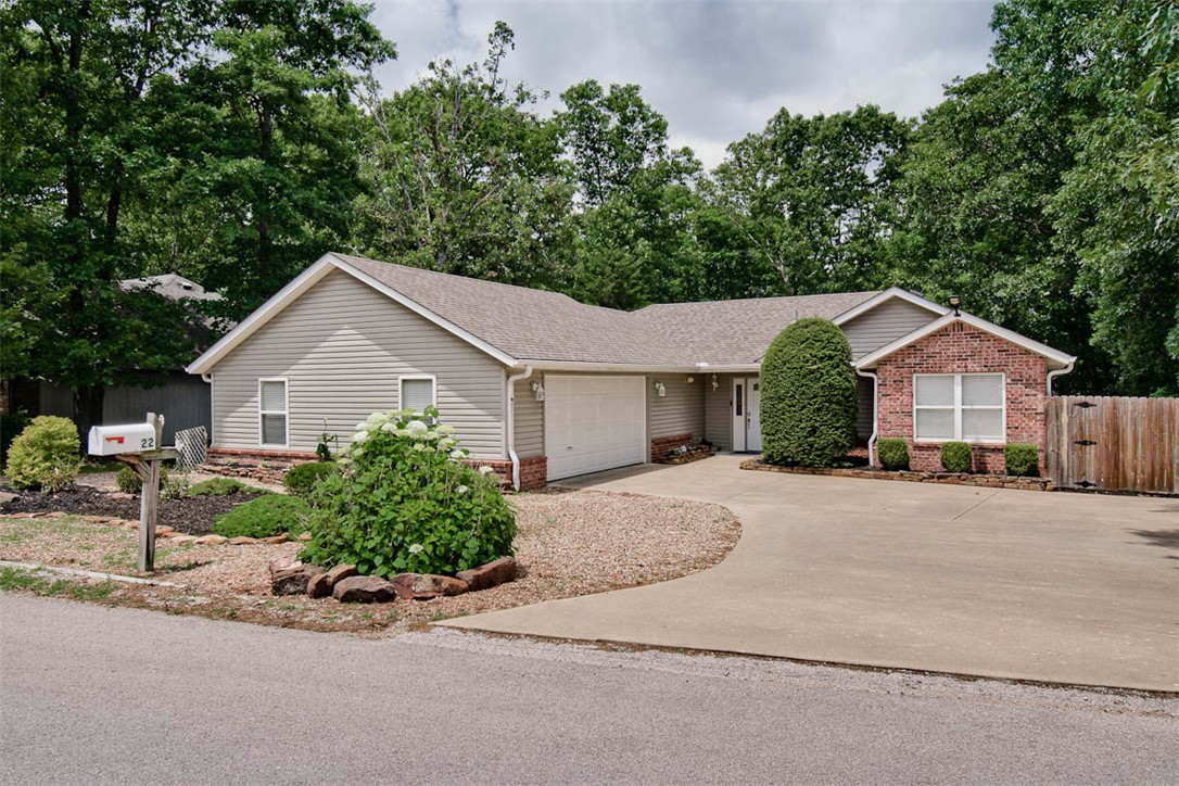 Bike, hike, and explore right from your doorstep! Nestled on Bella Vista’s highly sought-after east side, this beautifully updated home offers quick access to the Razorback Greenway, Back 40 Trail System, Blowing Springs, and OZ Trails Bike Park. Inside, you’ll find an inviting open-concept living area filled with natural light from a wall of windows overlooking the private wooded backyard. The updated kitchen features custom wood countertops, a farmhouse sink, painted cabinetry, and updated appliances for a warm cottage farmhouse feel. Recent improvements include fresh interior paint throughout, a new HVAC heat pump system in 2020, new roof in 2019, and a whole-home generator! The spacious primary suite opens to a heated and cooled sunroom, perfect for an office, reading nook, workout space, or second living area. Enjoy the expansive deck, peaceful wooded views, and privacy of an 8-foot wood fence, and a double gate providing convenient access to additional gravel parking. This location is unbeatable!!