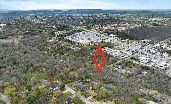 Situated at the corner of E. Sycamore and Walnut, this approximately one-third acre wooded lot offers both convenience and privacy. Just minutes from the NWA Mall and close to all the amenities you need, it's an ideal location that blends accessibility with a secluded feel. All utilities are available at the street, making it ready for your custom home build. Enjoy the spaciousness of this lot while still having room to create your private retreat in the city. Walking distance to new school with completion date of 2028. Don't miss your chance to own this prime piece of property—come see it before it's gone!