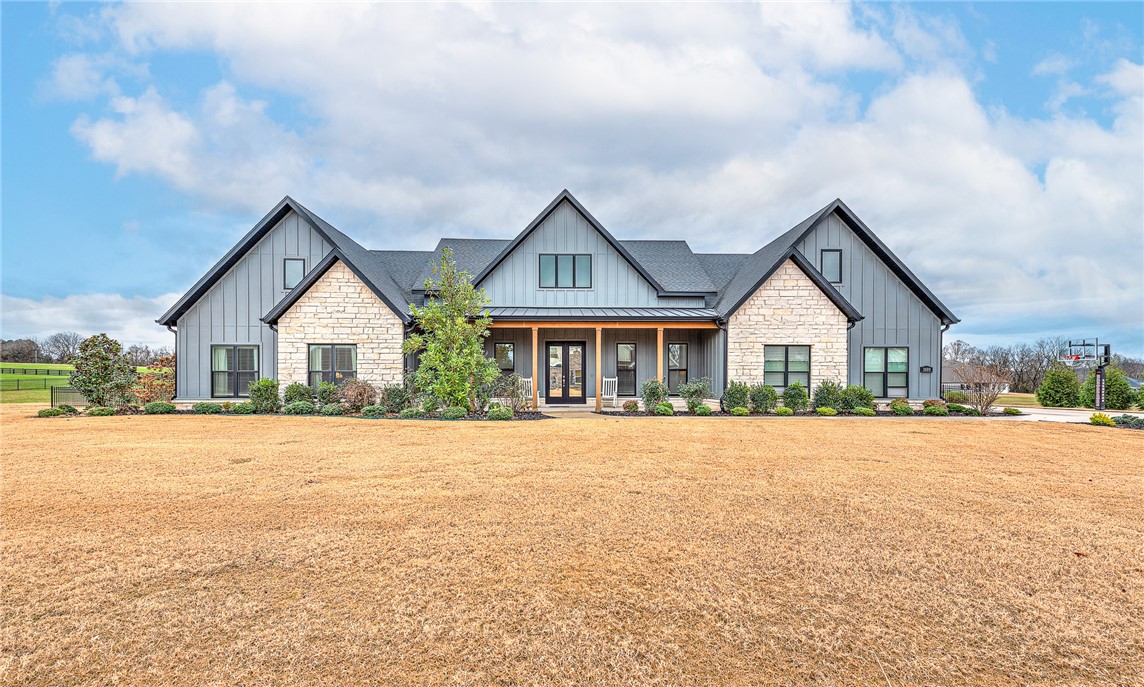 Experience modern farmhouse living at its finest in this stunning home set on 2.01 beautifully landscaped acres. This residence offers true main-level living with an inviting open floor plan, wood floors throughout, and high-end finishes at every turn. The main level features 5 spacious bedrooms and 4 full baths, while the only space on the second level is a generous bonus room with its own full bath provides flexible space—perfect as a 6th bedroom, guest suite, media room, or play area. A dedicated office makes working from home effortless. The gourmet kitchen is equipped with high-end appliances and overlooks the bright, open living and dining areas—ideal for entertaining. Step outside to your private retreat complete with a sparkling swimming pool w/ heated spa, screened-in porch, and a cozy fire pit surrounded by mature landscaping that enhances the beautiful setting. A rare combination of luxury, livability, and outdoor enjoyment—this modern farmhouse is truly one of a kind. Pool built by Midwest Pool & Spa