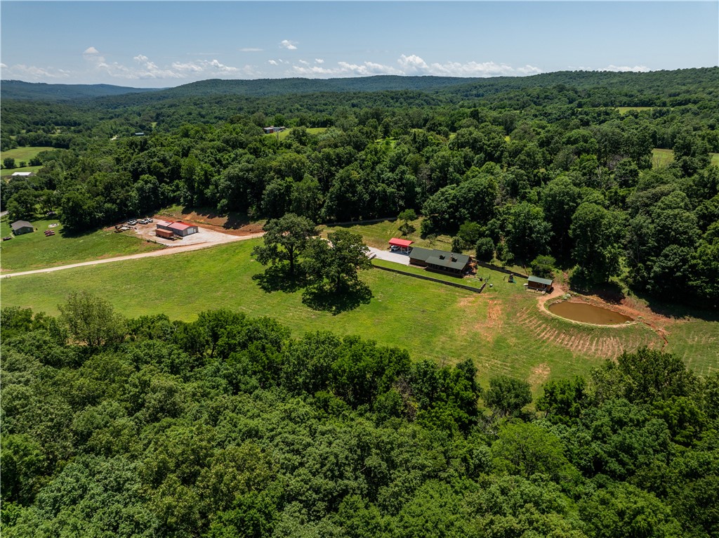 Charming Log Home on 88.35Acres MOL– Price reflects reduced acreage. Ideal for Farm, Recreation, or Homestead Living: Experience peaceful country living, scenic and productive land. On a paved road, this well-maintained property features approximately 40 acres of pasture and 48 acres of woods. Cross-fencing supports cattle, horses, or goats, and three barns provide ample space for equipment and storage. Enjoy spring fed pond and a year-round spring-fed creek, attracting abundant wildlife and offering reliable water sources. The beautifully renovated log home blends rustic charm with modern comfort. Spacious main-level bedrooms allow for convenient living, while the walk-up loft currently used as a bedroom and office offers excellent expansion potential.Perfect for a working farm, recreational retreat, or self-sufficient homestead. Bring your UTV and explore the land during your showing. Also listed additional land available MLS#1333428 and 1333429