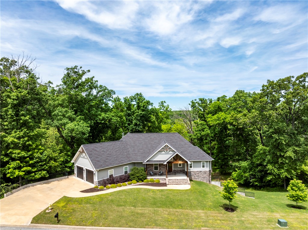Stunning 6 Bed 4 Bath home on 1.5 acres with breathtaking views from multi level composite decks. Seasonal view of Siloam Springs City Lake & walking distance to City Lake Park & miles of scenic trails. Step inside to soaring cathedral ceilings, walls of windows, & an abundance of natural light. Gourmet kitchen is a chef’s dream, featuring a five-burner gas range, instant hot water, & ample workspace. Open living area is anchored by wood beams & a striking stone fireplace with gas logs, complete with remote temperature control.Main level offers a spacious primary suite & a private in-law suite with its own mini kitchen.Primary suite has huge walk-in closet that connects to laundry room, custom walk-in shower & double vanities.Downstairs, offers a second living area, huge bonus room, three generously sized bedrooms, safe room & tons of walk-out attic storage.Enjoy outdoor living on two enormous composite decks & land with an invisible fence.Additional features include three HVAC systems with climate zones, extensive