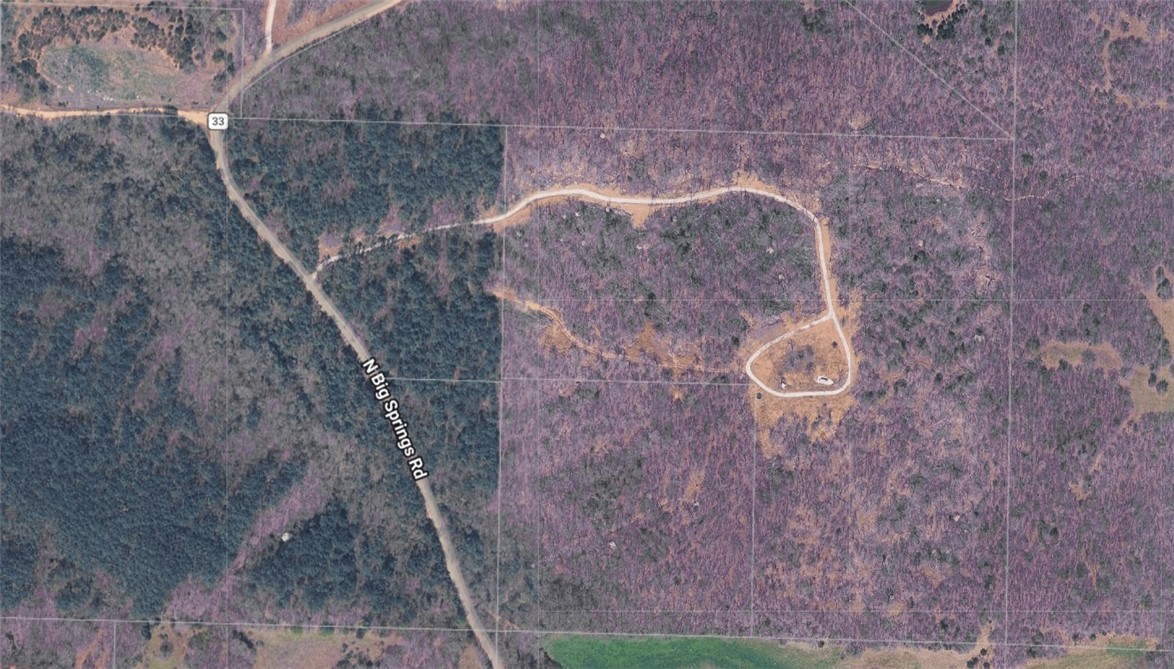 Discover the ultimate canvas for your dream estate in Gravette. This sprawling 38.77-acre property offers the perfect blend of rugged natural beauty and build-ready potential.  A cleared, graveled driveway makes it's way to a beautifully cleared area. While the majority of the acreage is lushly wooded, providing a permanent privacy buffer and a haven for local wildlife, the crown jewel is a stunning cleared area at the peak of the hill. Imagine waking up to these views from your front porch, surrounded by the quiet rustle of the forest. Whether you’re looking to build a modern architectural masterpiece or a cozy hilltop cabin, this land provides the seclusion you crave without sacrificing accessibility. Will need septic and well.