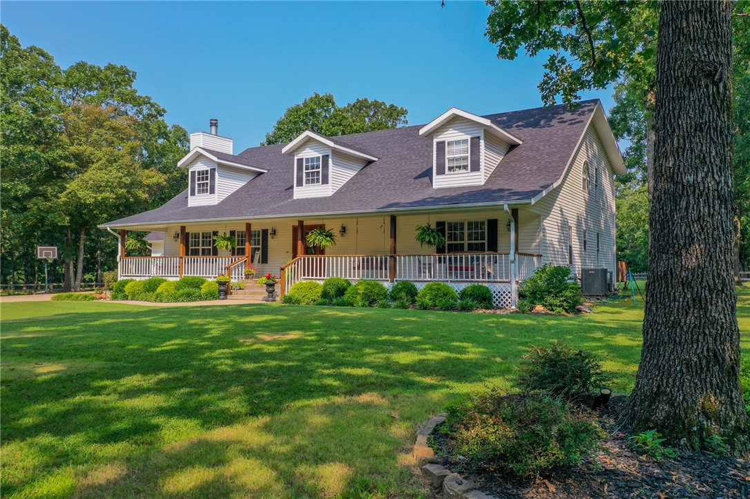 Experience the serenity of country living without the long commute! Nestled on 4.4 wooded acres, this expansive, fully renovated 4209 sf home with detached workshop is just 10 minutes from the I-49 Hiwassee exit and an easy 20 minutes from 102/N.Walton. Relish peace and quiet with your morning coffee or iced tea on either porch. The great room with adjoining formal dining and open kitchen, adorned with 3 cm quartz counters, glass-front cabinets, and ss appliances, are perfect for entertaining. The primary suite serves as a private sanctuary, featuring a roomy sitting area, an extensive walk-in closet with built-ins, and a luxurious bath with extra deep soaking tub, dual vanities, walk-in tiled shower, and separate toilet. All secondary bedrooms are spacious, offering ample closet space, and share a well-appointed second bathroom. The 2019-built barn includes a workshop/garage space and separate heated and cooled craft room. Both the front and back yards are fully enclosed, ensuring privacy and security.