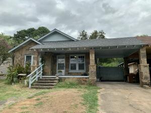 Charming in town cottage situated on a large parklike fenced lot.  Mature trees & lovely outdoor spaces to enjoy.  Dog run w/ custom home for ''Fido''.  Beautiful native rock exterior - new roof & HVAC (2021), HWH (2018), & updated bath w/ walk-in shower (2021).  Original hardwood flooring, trim, doors, & hardware add to the character.  Formal dining!  Spacious laundry w/ room for storage/bonus area.  Many windows add natural light creating a bright and airy space to enjoy!  This cozy home is a perfect place to call home.  Refrigerator, storage buildings, & gas range all convey!