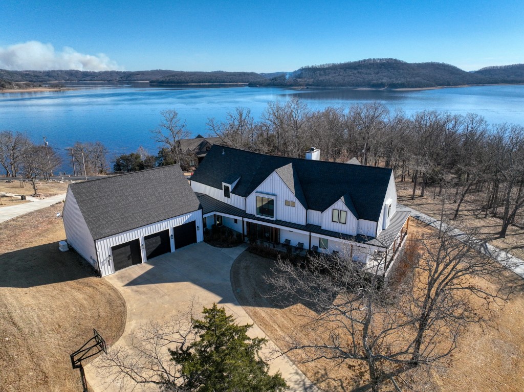 It’s easy to see why this recently constructed home was nominated for HGTV Best Waterside Retreat for 2022. It is a drop-dead gorgeous! Every surface is high-end and in excellent condition! This beautiful flat lot is a part of Del Lago Estates, one of the most sought-after gated subdivisions on Beaver Lake. Bring your friends and toys because two boat slips in the Del Lago community dock are included and are very close-by. Amazing details are everywhere, including two multi panel sliding glass doors which open the whole corner of the dining room and allow access to the huge screened-in patio! The stylish lower level also holds the large master suite and study. A floating staircase leads upstairs to the overhead cat-walk, a second large bedroom suite, and three other bedrooms. A large TV room and game room offer endless fun! You’ll love the oversized 3 car garage with it’s pull-through door that eliminates trailer backing. And the icing on this cake are the furnishings and furniture that are included!