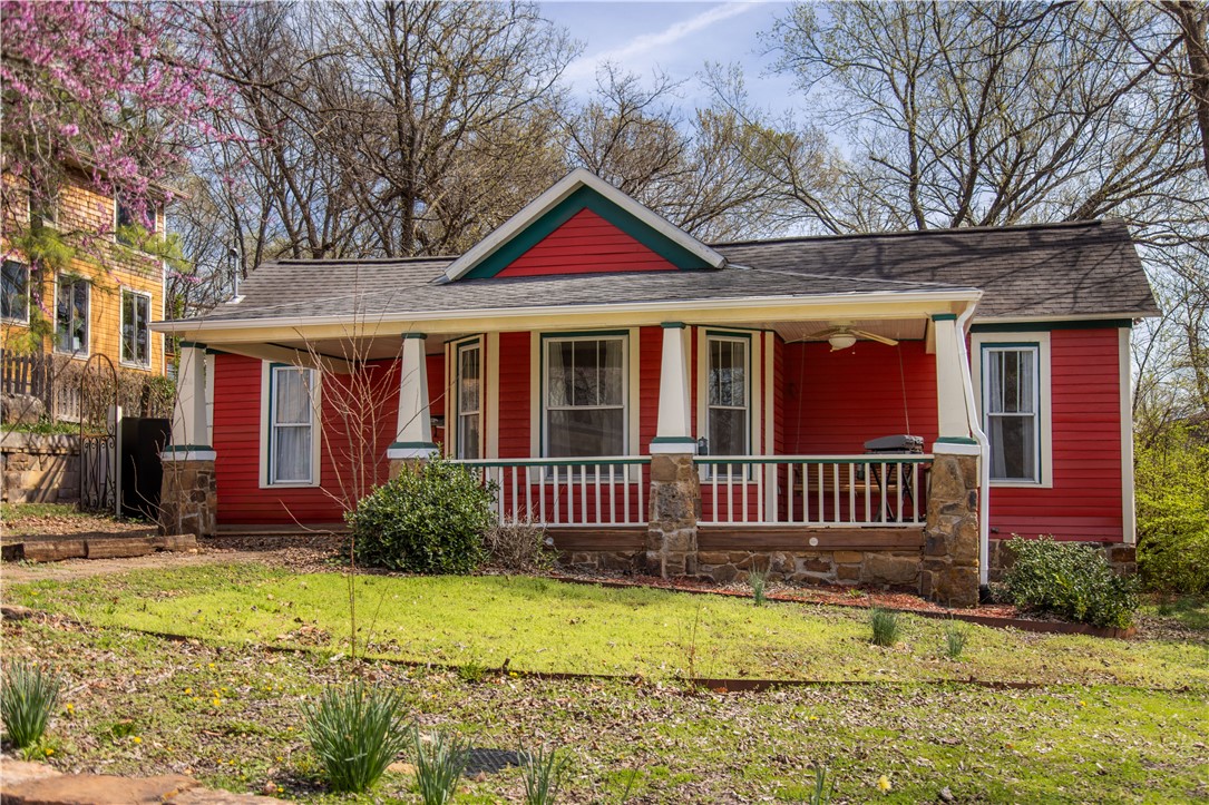 Charming Fayetteville home just two blocks from the Fayetteville Square. Originally built in 1925, this 1,323 sq ft residence offers 2 bedrooms, 2 baths, and sits on a 0.21-acre lot. Light-filled living spaces, a thoughtful layout, and original refinished hardwood floors add warmth, while a refreshed kitchen blends historic charm with today’s convenience. Recent updates include a refitted foundation, French drain along the North side to protect the basement, a 2023 heat pump, & a 2024 water heater for modern comfort. In 2024, siding was replaced where needed & the exterior repainted for lasting curb appeal. Ideal for buyers seeking walkable/bike-able access to the U of A, Downtown Fayetteville dining & shopping, Razorback Greenway, & parks. The oversized front porch has a view of the Boston Mountains to the South & is fitted with a porch swing for two, & the expansive backyard offers a quiet sanctuary in the heart of downtown Fayetteville with the potential to add an Accessory Dwelling Unit. Schedule a tour today!