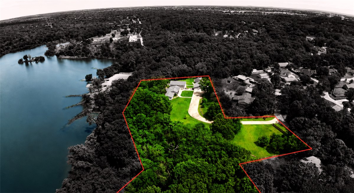 Stunning lakefront estate offering exceptional privacy, luxury, & breathtaking views. This expansive 6,057 sq ft home features 3 beds & 3 baths, including 2 primary suites with private living areas. Two additional spacious living areas, a formal dining room, secure safe room, abundant storage, & direct patio access from every room create seamless indoor-outdoor living. A guest house located at the rear of the 3-car garage offers 510 sq ft with a studio apartment/mother-in-law suite, complete with an indoor pistol range/walk-in closet. Additional 2-car garage plus ample guest & RV parking provide exceptional flexibility. The expansive deck and stone patio feature a step-down fire pit & decorative waterfall feature (currently not operational but able to be restored). Thoughtfully designed with well-separated living spaces, this unique property offers endless possibilities as a private luxury residence, multi-generational retreat, executive getaway, conference-style setting, or potential income-producing opportunity.