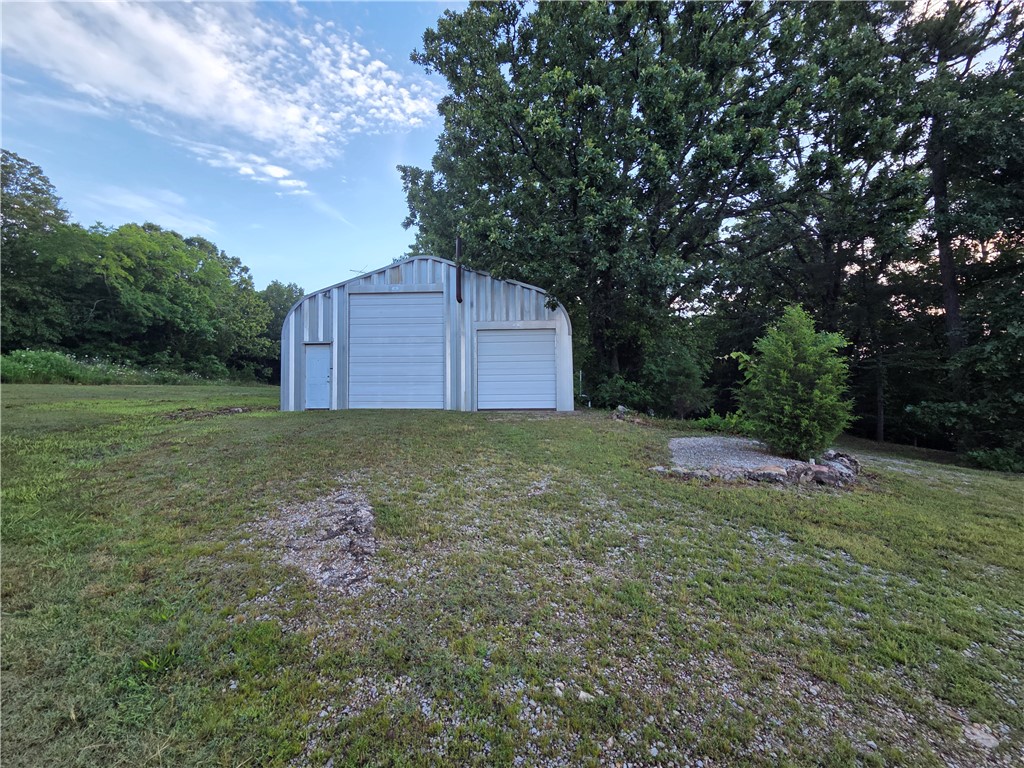 Prime location 2 miles to Eureka Springs & 4 miles to Berryville. Two side-by-side lots (1.3ac & 1.2ac) w/ Hwy 62 frontage, & a 1.5ac lot joining behind at end of short county road. All lots have well water access & gas line availability.  The 1.3-acre is served by 30+ft. asphalt apron off HWY & features a 30x40 metal shop on concrete slab w/ 2 roll-up doors. Inside is shop space, 1-bedroom, 1-bathroom living quarters w/ appliances, window AC, & propane wall heater. Shop space also has propane hookup, 220V Electric, wood stove, & massive amount of loft storage. Shop/Living quarters and the 2 RV spots served by full septic system. Also features a 24x24 2-car garage on concrete slab, 2 RV set-up spots w/electric, water, & sewer dump. Minutes away from Kings River & Beaver Lake. Only 45+ minutes to Branson, MO. & Table Rock Lake. If you're looking for a workshop, home building site, home base for RV, Commercial venture, or multi-lot investment, this property offers incredible infrastructure in a high-visibility area.