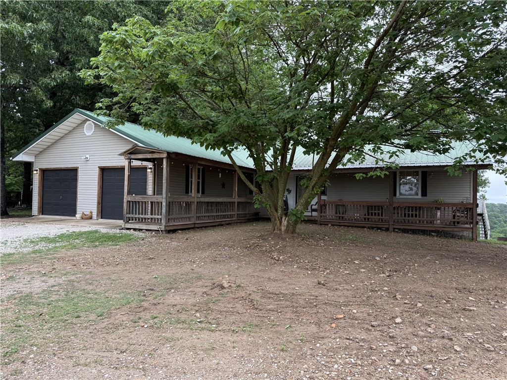 Nestled in the Ozark Mountains near the Buffalo National River area, this approx. 1.3 acre property offers space, and distant mountain views! This 4 bedroom, 3 full bath home features a functional layout with 2 bedrooms and 2 full baths on the main level, along with a spacious living room conveniently located just off the kitchen and dining area. Enjoy relaxing outdoors from the covered front porch or the covered back deck overlooking the scenic Ozark landscape. The walk-out basement offers additional living space with 2 bedrooms, a full bath, and a kitchenette—ideal for guests, multi-generational living, vacation use, or additional entertaining space. Located in the heart of outdoor recreation with nearby hiking trails, the Buffalo River, and Ozark adventure opportunities just a short drive away.  Just 10 minutes from Western Grove, AR on Hwy 123.