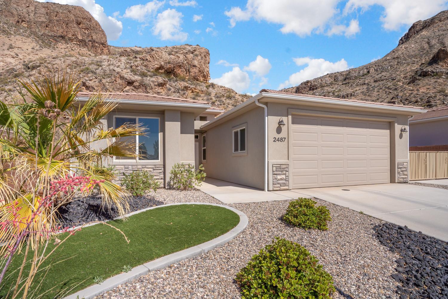 Backing to mountains with no neighbors behind, this contemporary home offers something rare: peace, presence, and a prime neighborhood location. Hike trails nearby. Walk to the park right down the street! 

Inside, the foyer opens to a bright great room designed for entertaining and
everyday relaxation. The living area features a fireplace and flows naturally into the dining space and kitchen, then directly to the patio for your outdoor hangouts. The kitchen has quartz
countertops and a breakfast bar ready for casual bites and conversation. Nearby, the laundry comes equipped with Samsung front-loaders and opens directly to the garage. The home's primary suite looks out over the yard and the mountain beyond, with a spa-like primary bath
featuring a quartz vanity, soaking tub, separate shower, and walk-in closet with organizers. There's a second bedroom and full bath for family and guests, and a third bedroom that easily doubles as a home office. Outside, the fully fenced yard makes the most of its unique setting with a shaded patio, turf area, and low-maintenance desert landscaping, all set against the solace of the mountain. The two-car garage sits next to your gated side yard with RV parking and full hookups. Town is a short drive away, with all the natural beauty and adventure of south Utah as an extension of your backyard. Welcome home!