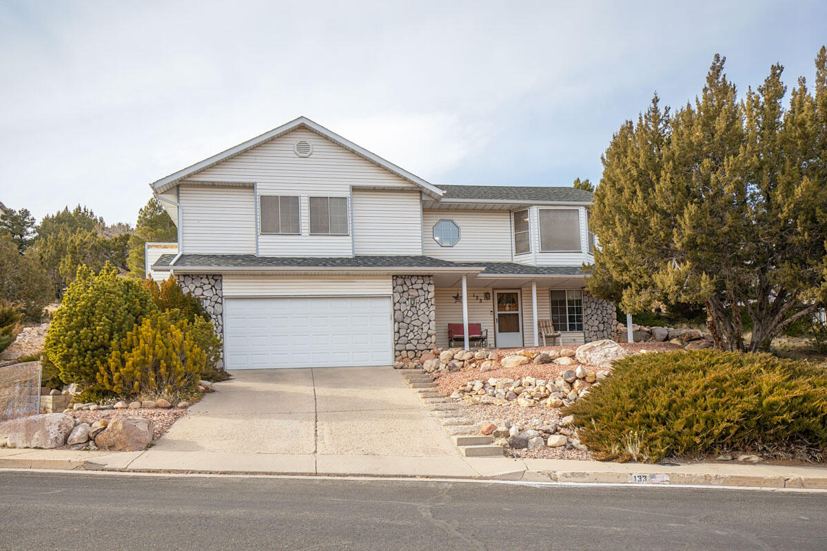 Welcome home to this spacious 5-bedroom, 3-bathroom residence in the desirable Beacon Hill subdivision of Cedar City. With 3,717 square feet of living space on a 0.28-acre lot, this reverse-entry home offers incredible views, functional living areas, and room to grow. The upper level features three bedrooms, including the primary suite, along with beautifully remodeled bathrooms, a large kitchen, dining area, and an inviting living room with fireplace. Hardwood, tile, and carpet flooring add warmth and character throughout. The layout is ideal for everyday living and entertaining. Downstairs, you'll find two additional bedrooms, a full bathroom, a generous family room, laundry area, and ample storage. The daylight, walk-out basement provides flexible space for guests, hobbies, or multigenerational living. Additional highlights include a 2-car attached garage, covered patio and porch, partially landscaped yard, natural gas forced-air heating, evaporative cooling, and no HOA. Conveniently located near schools, shopping, dining, and quick access to HWY 56, this home combines comfort, space, and location. If you've been searching for a large Cedar City home with views and updated finishes, this Beacon Hill property is ready to welcome you home.