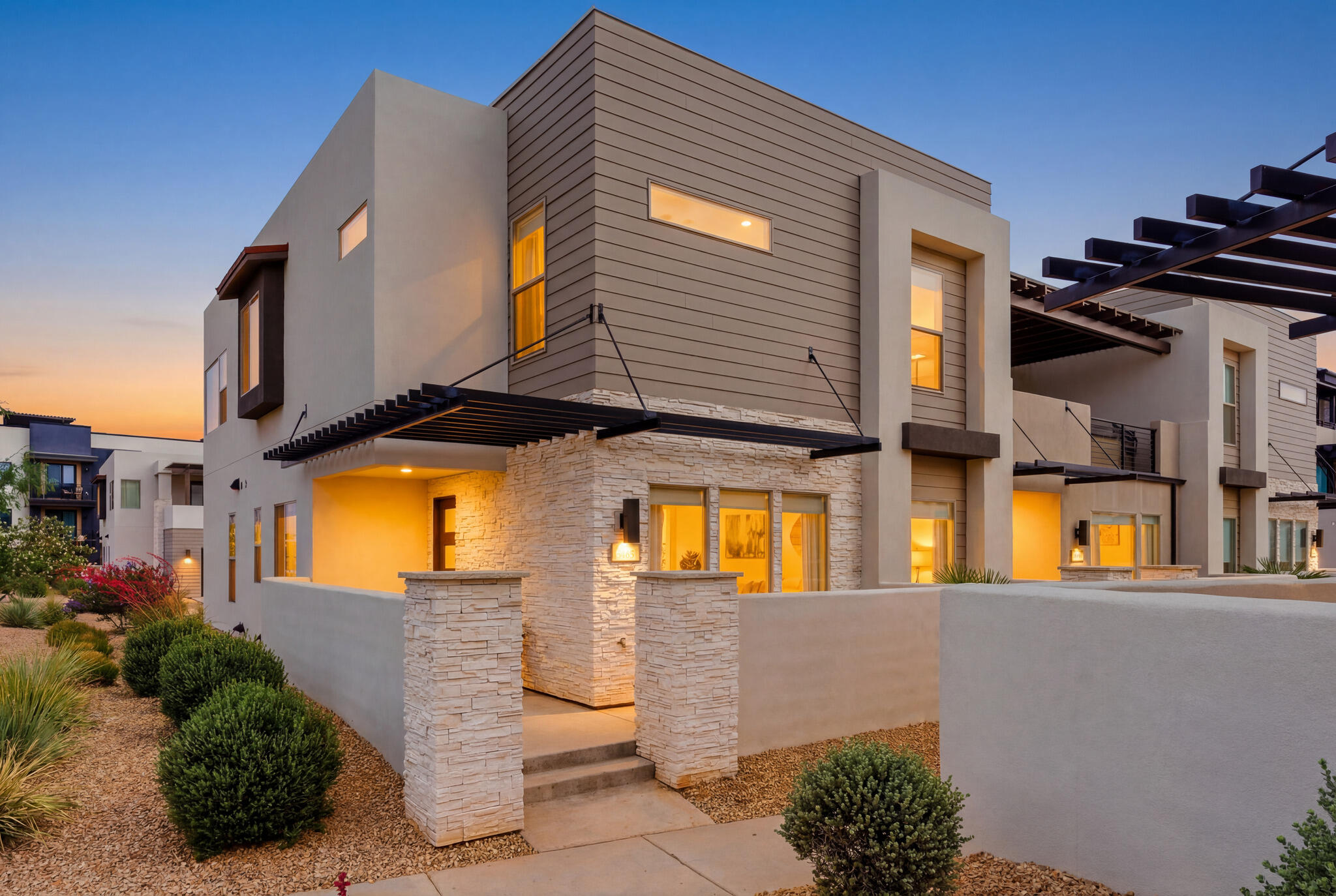 Experience elevated resort-style living in Desert Color with this row-end townhome, built in 2022 and offering 5 bedrooms, 5 bathrooms and 2,608 square feet. Ideal as a nightly rental investment, weekend retreat or full-time residence, this home was designed for gathering, comfort and lasting memories.  A welcoming front porch with BBQ area sets the tone for outdoor entertaining. Inside, natural light fills the open layout with a spacious great room, two dining areas and a kitchen featuring a center island, pantry, under-cabinet lighting and seamless connection to the main living spaces. Ceiling fans are placed throughout, including every bedroom, the great room and upstairs living room.  The floor plan offers two bedrooms and two bathrooms on the main level, with three bedrooms and three bathrooms upstairs. Three bedrooms are private en-suites, while the additional bedrooms enjoy direct bathroom access. One bedroom is designed as a custom bunk room sleeping four, complete with individual lighting and outlets.  Upstairs, a second entertainment living room offers another gathering space with a dining/card table and access to a private balcony featuring a hot tub, fire pit, TV and lounge seating. Additional highlights include tile-to-ceiling shower surrounds, TVs throughout, dedicated laundry room, linen closet, zoned forced air and A/C, stair lighting, tankless water heater, water softener and a two-car garage with EV charging outlet.  Located within walking distance to Desert Color's amenities, enjoy the 2.5-acre lagoon beach, heated pools, pickleball courts, parks and trails. With nightly rentals allowed, a row-end location and indoor-outdoor gathering spaces, this townhome offers an ideal blend of lifestyle, flexibility and investment potential.