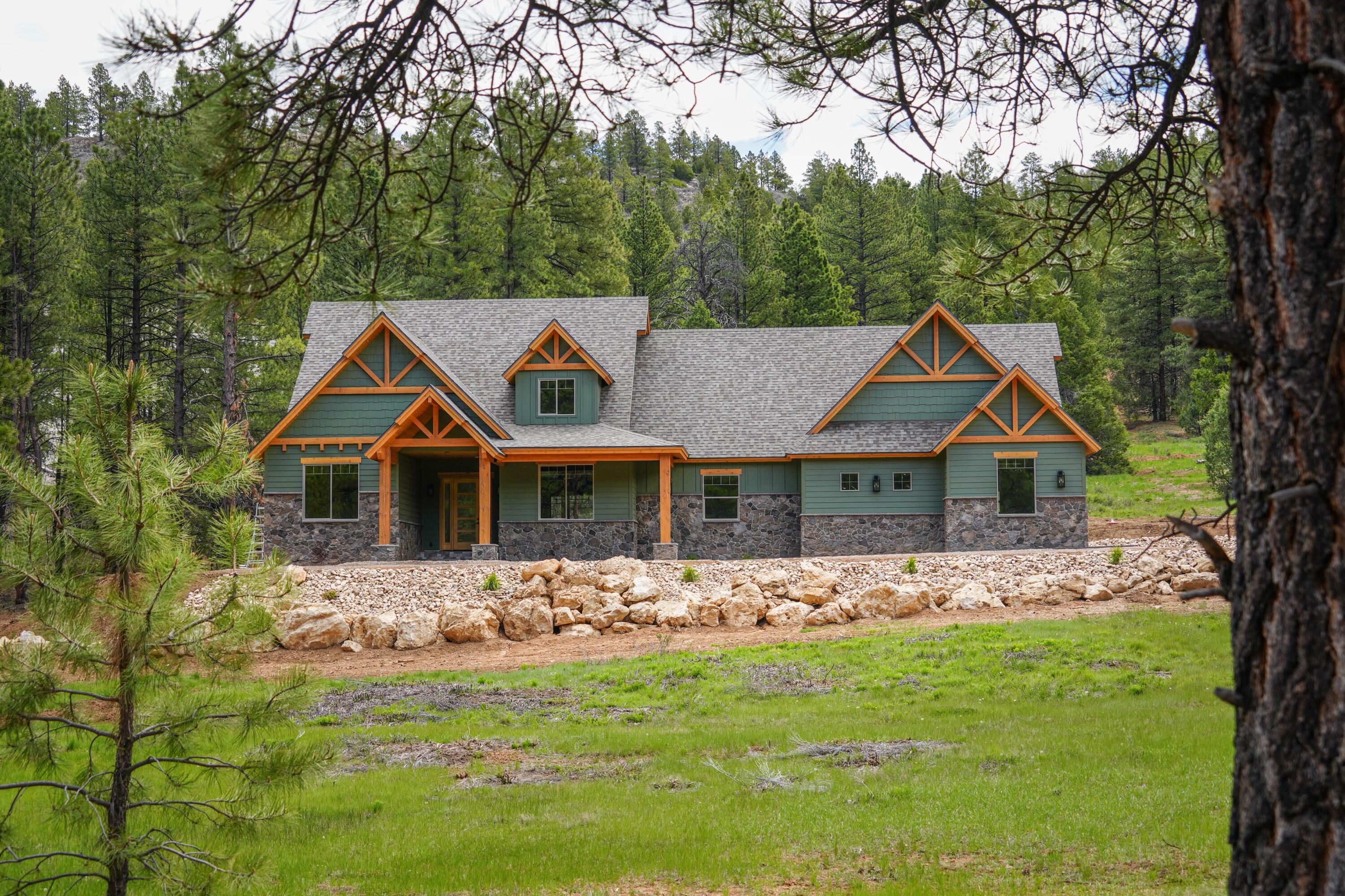 Experience refined mountain luxury in one of Southern Utah's most breathtaking settings. Situated on 2.93 private acres with year-round access, this exceptional cottage retreat blends craftsmanship, comfort, and serene mountain living. The home features 3 bedrooms and 2 bathrooms, including a main-level primary suite, inviting living spaces, and a stunning brick fireplace. The kitchen offers stainless steel appliances, generous workspaces, and an open layout perfect for gathering. Enjoy relaxing or entertaining on the back patio with the added convenience of a two-car attached garage. Upstairs, a bonus room offers expansion potential for two additional bedrooms and a bathroom. Perfect for family retreats, romantic escapes, or entertaining, this cabin captures the beauty and adventure of Southern Utah.