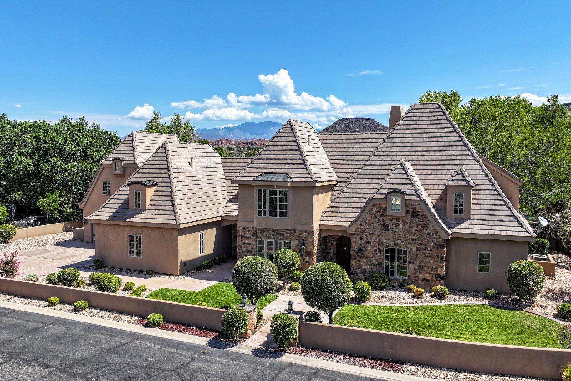 Welcome to this exceptional French Country-inspired estate, tucked within an exclusive luxury gated community located near the Santa Clara River and only minutes from the vibrant dining, shopping, and entertainment of downtown St. George. Rarely lived-in second home, this residence offers timeless elegance. The arched front entry sets the tone for the home's distinctive architectural character. Inside, soaring ceilings are accented by stunning wood gable beams in the living room, creating a warm yet sophisticated gathering space. Travertine stone flooring flows throughout the main living areas, while beautiful wood cabinetry, granite countertops, and premium Viking appliances elevate the beautifully appointed kitchen and continue throughout the home. Designed with both luxury and functionality in mind, the expansive primary suite is a true retreat, featuring the rare convenience of two separate bathrooms for ultimate comfort and privacy. Three separate staircases lead to 3 bedrooms and two versatile loft areas, offering flexible space for a media room, office, fitness area, or additional gathering space. Throughout the home, an abundance of thoughtfully designed storage ensures there's a place for everything without compromising the home's elegant aesthetic. Situated on an oversized .47-acre lot, the property provides abundant outdoor space with endless possibilities for entertaining, relaxation, or creating your dream backyard oasis. This property is also a short drive to some of America's most breathtaking destinations, including Zion National Park, Bryce National Park, and the north rim of the Grand Canyon. Other nearby state parks and national forests include Sand Hollow Reservoir, Gunlock Reservoir, Quail Creek Reservoir, and Dixie National Forest that enhance the allure of the location.