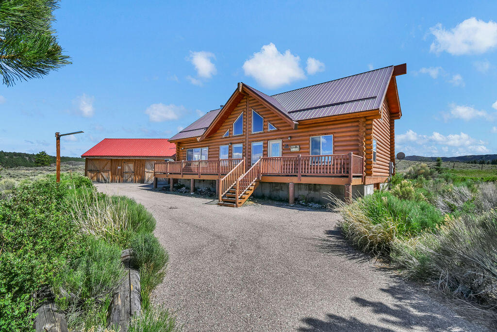 Escape to the mountains and enjoy the perfect summer retreat overlooking beautiful Panguitch Lake. Nestled on 0.61 acres, this charming 2-bedroom, 2-bathroom log cabin offers approximately 2,160 square feet of comfortable living space, breathtaking lake views, and the peaceful mountain lifestyle you've been dreaming of. The main level features an open floor plan with vaulted ceilings, a spacious living room, large kitchen with abundant cabinet space, hardwood and tile flooring, a cozy wood-burning stove, one bedroom, one full bathroom, and a laundry area. The dining area features double sliding glass doors that open directly onto the expansive deck, creating seamless indoor-outdoor living and providing easy access to one of the home's most impressive features. Step outside onto the spacious front deck and take in the spectacular panoramic views of Panguitch Lake. Positioned to capture the beauty of the sparkling water, surrounding mountains, and breathtaking sunsets, this outdoor living space offers the perfect setting for morning coffee, entertaining guests, wildlife watching, or simply relaxing and enjoying the peaceful mountain atmosphere. The incredible lake views create a true sense of escape and make this property a destination you'll never want to leave. Upstairs, you'll find an oversized loft area, an additional bedroom, and a large bathroom complete with a clawfoot tub and separate shower. Vaulted ceilings continue throughout the upper level, creating a spacious and inviting atmosphere. Outside, enjoy the large lake-view deck, a three-car garage for vehicles and recreational toys, an asphalt driveway, partial fencing, and a durable metal roof. Whether you're looking for a seasonal getaway, vacation rental opportunity, or year-round mountain home, this property offers endless possibilities in one of Southern Utah's most desirable recreational destinations. Enjoy fishing, boating, ATV trails, hiking, hunting, and year-round outdoor recreation just minutes from your doorstep. Don't miss this opportunity to own your own mountain retreat with incredible views of Panguitch Lake.