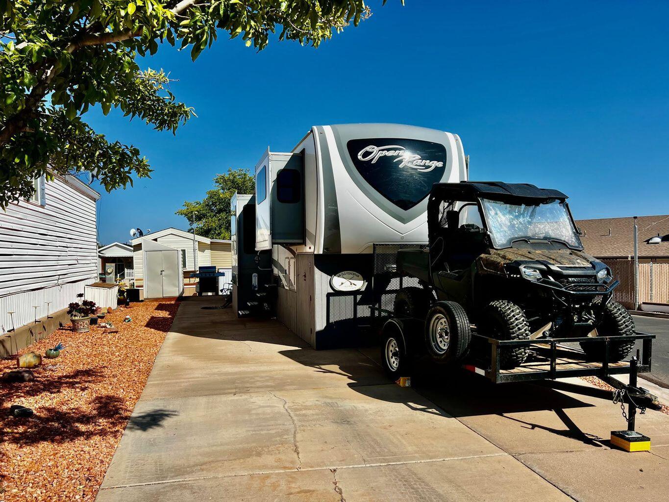 Come one, come all and see this beautiful lot located across from the pool and clubhouse. The spacious lot features a lovely, decorated side yard and includes a shed. Also included in the purchase is a 2018 Open Range by Highland Ridge fifth wheel featuring five slides, dual A/C units, double refrigerator, kitchen island with sink, king-size rear bed, step-in shower, washer/dryer hookups, fireplace, vinyl plank flooring, sliding hitch, and storage under the gooseneck. Enjoy the 60-inch TV and comfortable swivel recliners. Buyer to verify all information.