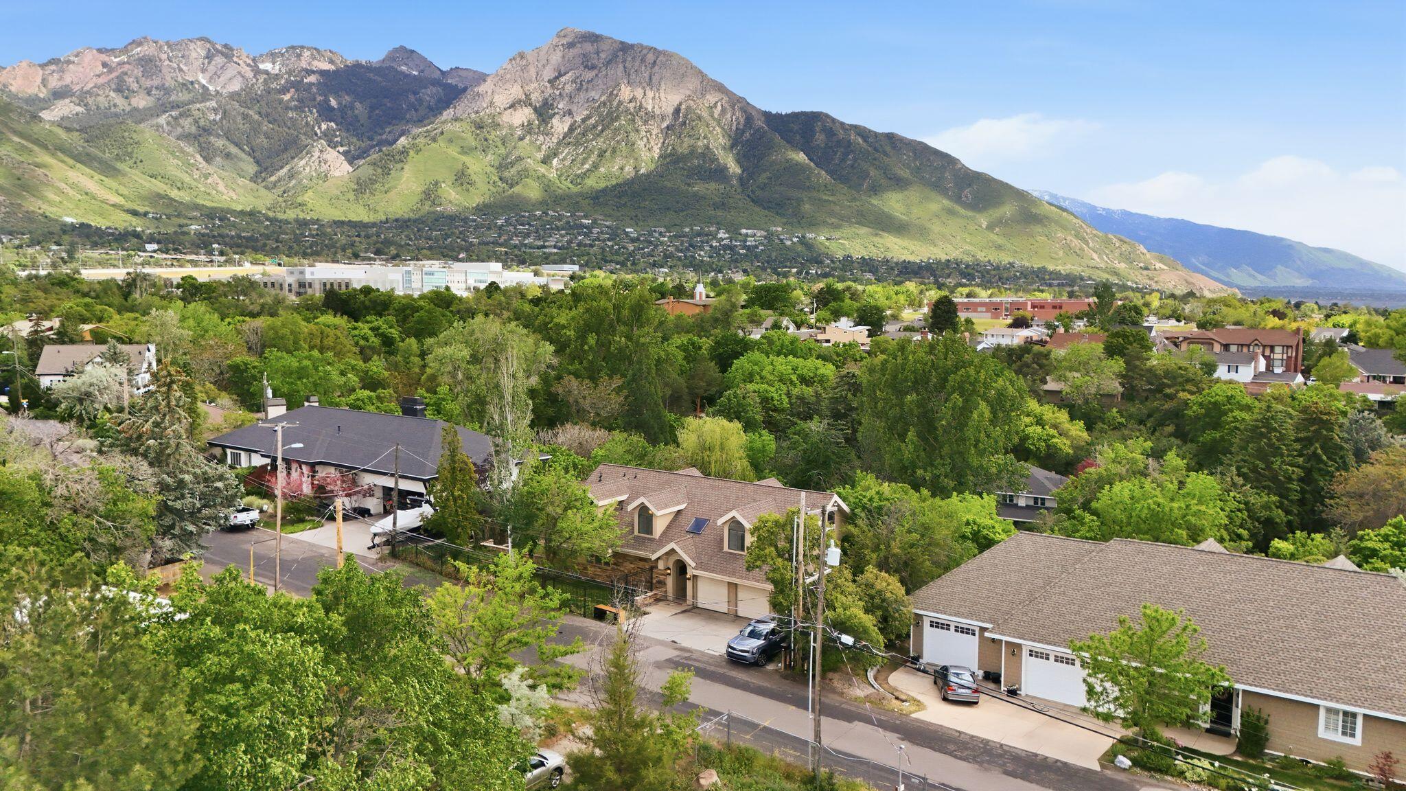 Tucked away along Millcreek Canyon Road, this hidden gem offers a rare blend of privacy, natural beauty, and breathtaking scenery. With Millcreek stream flowing through the backyard, the property feels like a private mountain retreat where you can enjoy the sounds of the creek, watch local wildlife, and enjoy the fish right from your own backyard. Surrounded by mature trees and lush landscaping, the setting is truly one of a kind. Inside, expansive windows frame stunning views of Mount Olympus and the Salt Lake Valley, bringing the outdoors in. The thoughtfully designed kitchen features granite countertops, a Sub-Zero refrigerator, warming drawers, stainless steel appliances, and abundant workspace for cooking and gathering. The open-concept layout flows seamlessly into the family room, while multiple decks create the perfect spaces for entertaining or simply taking in the incredible surroundings. Additional highlights include vaulted wood-beam ceilings, radiant heat, a wood-burning fireplace, and a bright walkout lower level that opens directly to the heated swimming pool with diving board. Upstairs offers flexible living space ideal for bedrooms, a home office, or a den, all with beautiful canyon and mountain views. Located near exceptional public and private schools with convenient freeway access, this property offers the perfect balance of peaceful canyon living and city convenience. Outdoor living truly doesn't get better than this.