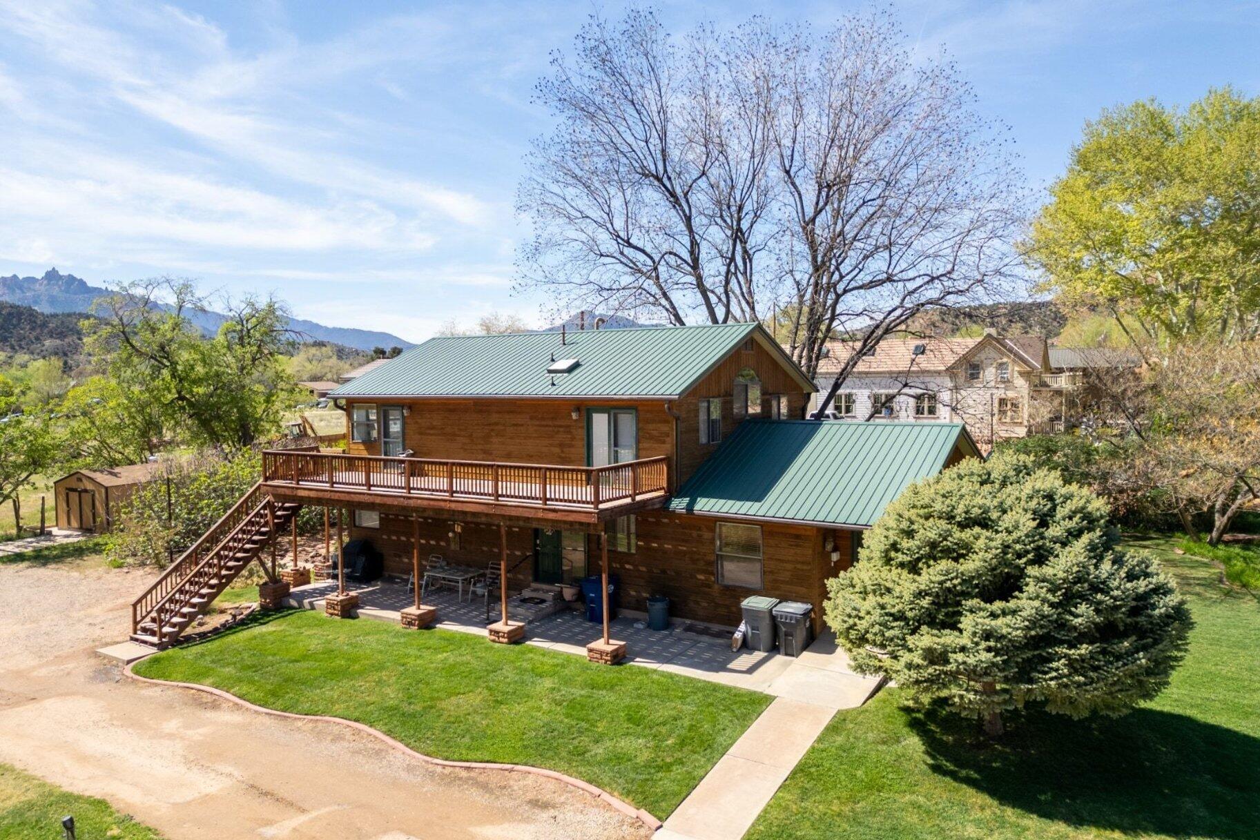 COMMERCIAL PROPERTY I MILE FROM ZION NATIONAL PARK ENTRANCE. This .41 acre property is in the Central Commercial Zone of Springdale and can be used as a nightly rental. Three over-sized bedroom suites with are perfect for hosting large families or even multi-family short-term rentals. It comes with power, city water and sewer and 2.5 shares of irrigation water. This parcel along with the adjacent .51 acre parcel combined, make .92 acres in the highly coveted commercial property along Zion Park Blvd where over 5 million visitors pass by annually!