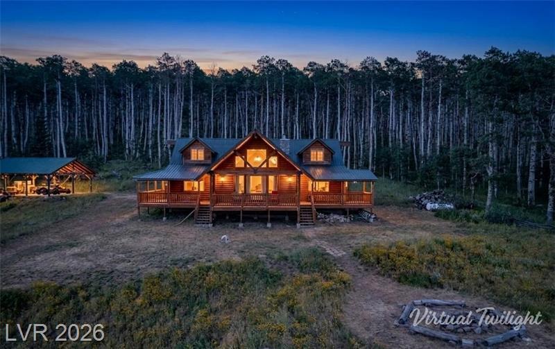 Commanding an elevated position on 20 acres of quakies & open meadow, this cabin captures the majesty of expansive mountain views, open skies, & unspoiled wilderness in every direction. A hunter's haven & mountain sanctuary, it's surrounded by prime deer, elk, & turkey habitat. A pavilion provides a great space for gatherings, parties, & outdoor entertaining. Inside, beautiful rustic log furnishings throughout, vaulted ceilings, & a hand-laid rock fireplace create warm western charm. The main floor offers a great room, dining area, kitchen w/pantry. A primary bedroom w/ en suite, half bath & a mother-in-law's room. Upstairs in the loft features a family room, full bathroom & 3 queen beds. Dish TV keeps you connected, & non-potable deeded spring water is pumped to a tank & gravity fed. Seasonal access. Seller financing available. Adjacent 20 acres available. Selling turn-key.