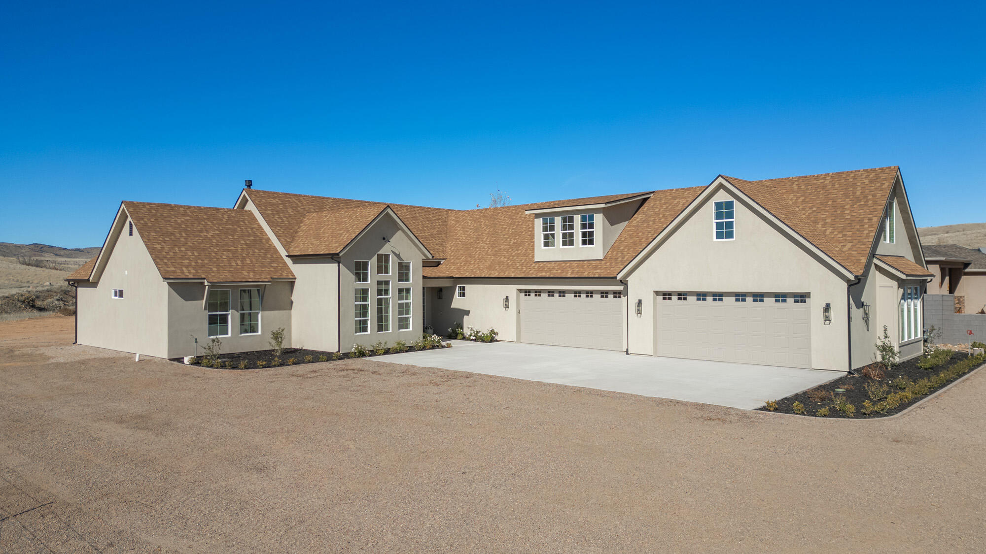 Stunning brand-new home w/a 4 bedroom, 3.5 bath design offers main-level living on a spacious .53-acre lot! The versatile den can serve as a formal dining, an office, media, study or 5th bedroom. This home boasts vaulted ceilings with striking wood beams, beautiful fireplace, 4-car garage, & large open- concept kitchen with a generous hidden walk-in pantry. The master bath is a true retreat, featuring a luxurious freestanding tub & separate his/her walk-in closets.The bonus space above the garage provides many opportunities with its own kitchenette, bedroom, bathroom, & living area, all with private access. Come appreciate the breathtaking hillside views of this beautiful home nestled in a peaceful country setting with easy access to outdoor adventures & small- town charm. Don't miss out!
