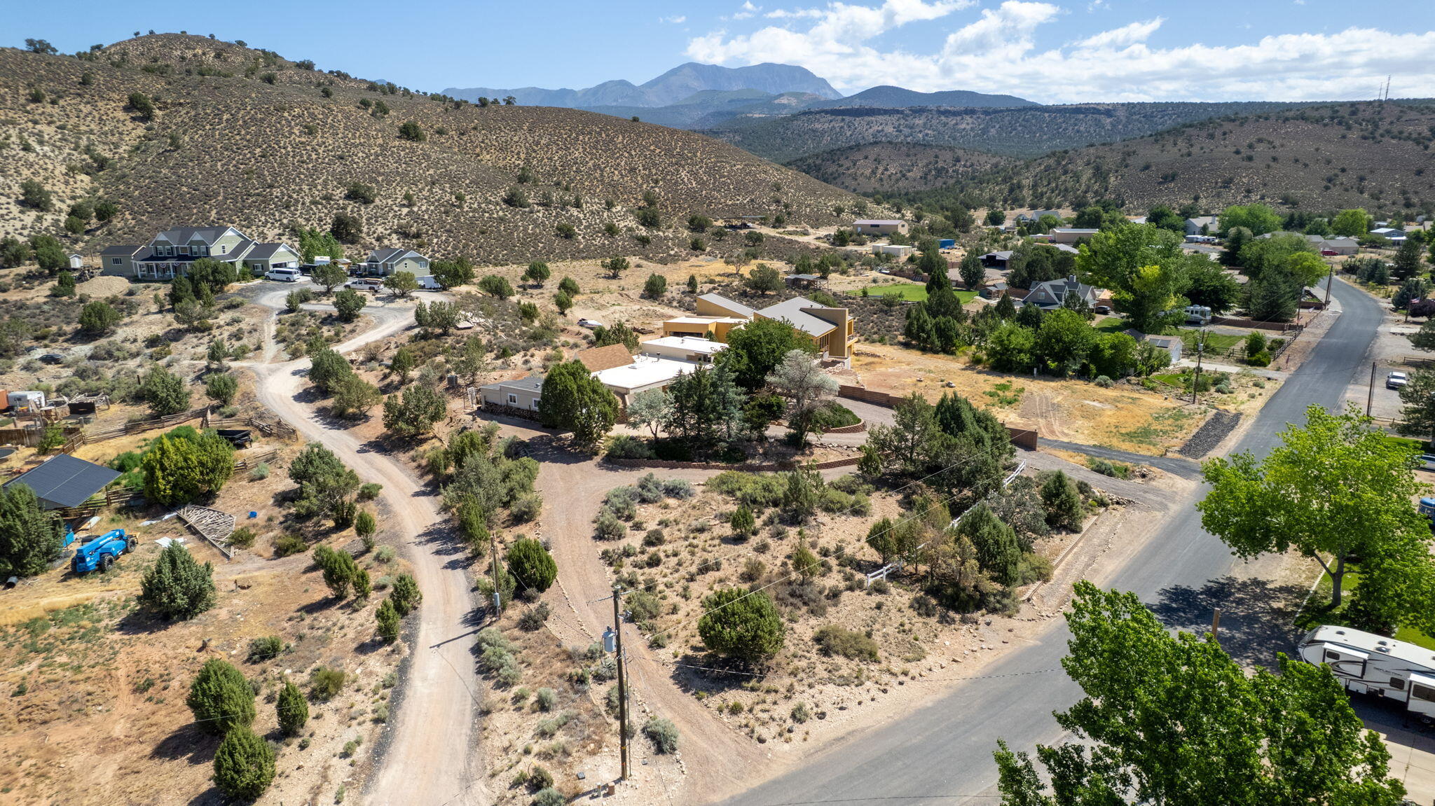 Tucked away in the peaceful community of Diamond Valley, this solid home sits on nearly a full acre with mountain views, mature trees, and room to breathe. Inside, the kitchen flows into a bright dining area with vaulted ceilings and skylights that flood the space with natural light. The cozy living room features a wood-burning fireplace and built-in shelving, while the upper level primary suite includes a private balcony and a separate laundry room with storage and shelving. A spacious covered patio and courtyard make the backyard ideal for outdoor living and entertaining. The detached 667 sq/ft garage offers room for vehicles, storage, or a workshop, in addition to the 2-car attached garage. With no HOA and a relaxed rural feel just minutes from St. George amenities, this one offers the best of both worlds.