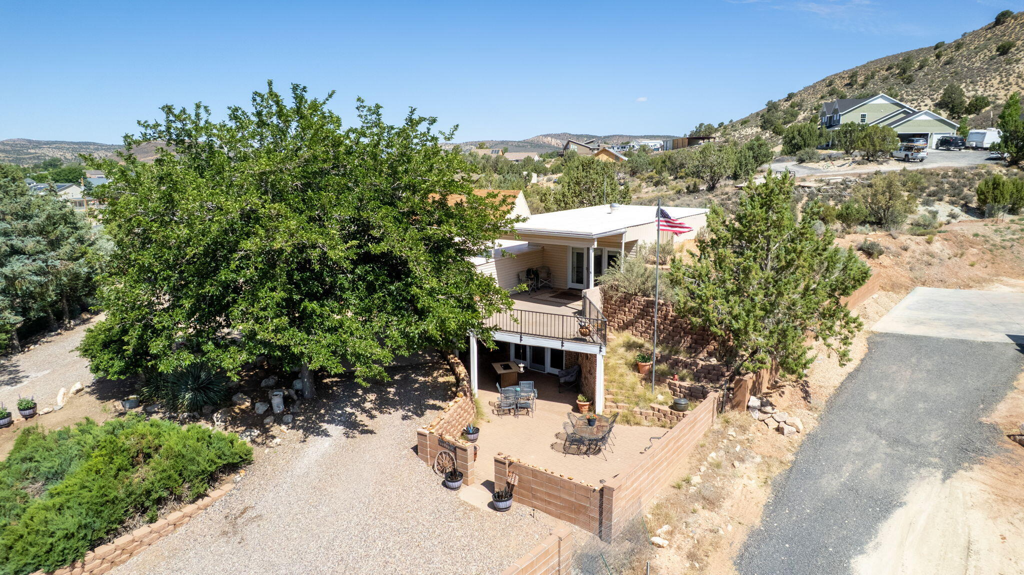 Tucked away in the peaceful community of Diamond Valley, this solid home sits on nearly a full acre with mountain views, mature trees, and room to breathe. Inside, the kitchen flows into a bright dining area with vaulted ceilings and skylights that flood the space with natural light. The cozy living room features a wood-burning fireplace and built-in shelving, while the upper level primary suite includes a private balcony and a separate laundry room with storage and shelving. A spacious covered patio and courtyard make the backyard ideal for outdoor living and entertaining. The detached 667 sq/ft garage offers room for vehicles, storage, or a workshop, in addition to the 2-car attached garage. With no HOA and a relaxed rural feel just minutes from St. George amenities, this one offers the best of both worlds.