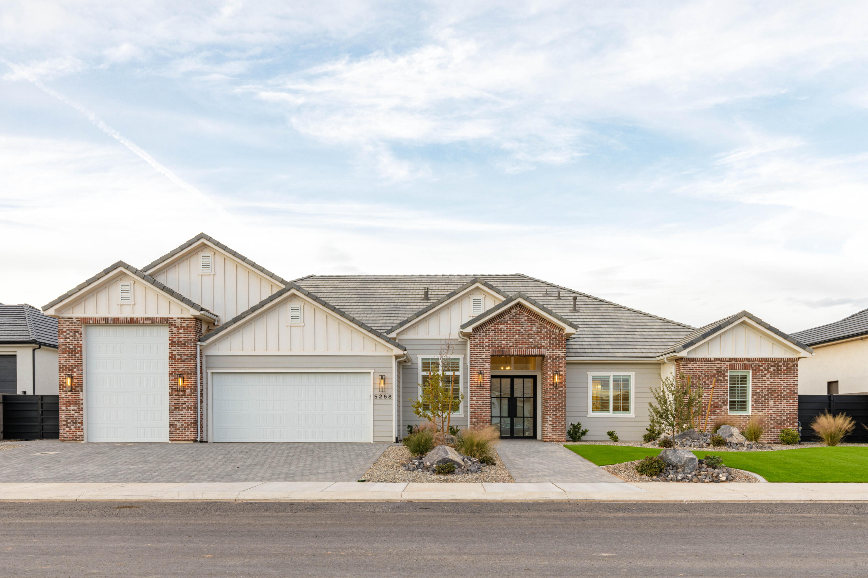 Stunning lightly lived in New Trend Construction home ideally located in desirable Sycamore Village neighborhood, 7 minutes from Sand Hollow State Park! Boat garage with epoxy flooring. Open floor plan with 10'+ ceilings throughout, big picture windows to bring in natural light & every bedroom includes its own en-suite bathroom, providing privacy and comfort for family and guests alike. Chef's kitchen upgraded with oversized fridge & freezer, GE Cafe appliance package, range hood & large walk-in pantry. Luxurious primary suite with blackout blinds, dual vanities, extra cabinetry, free-standing tub & walk-in shower creating a spa-like atmosphere. Other upgrades include motorized blinds, plantation shutters, hardwood flooring, designer tile, quartz countertops, custom millwork/cabinetry & ample storage. This home provides beauty, comfort, luxury & practical living.