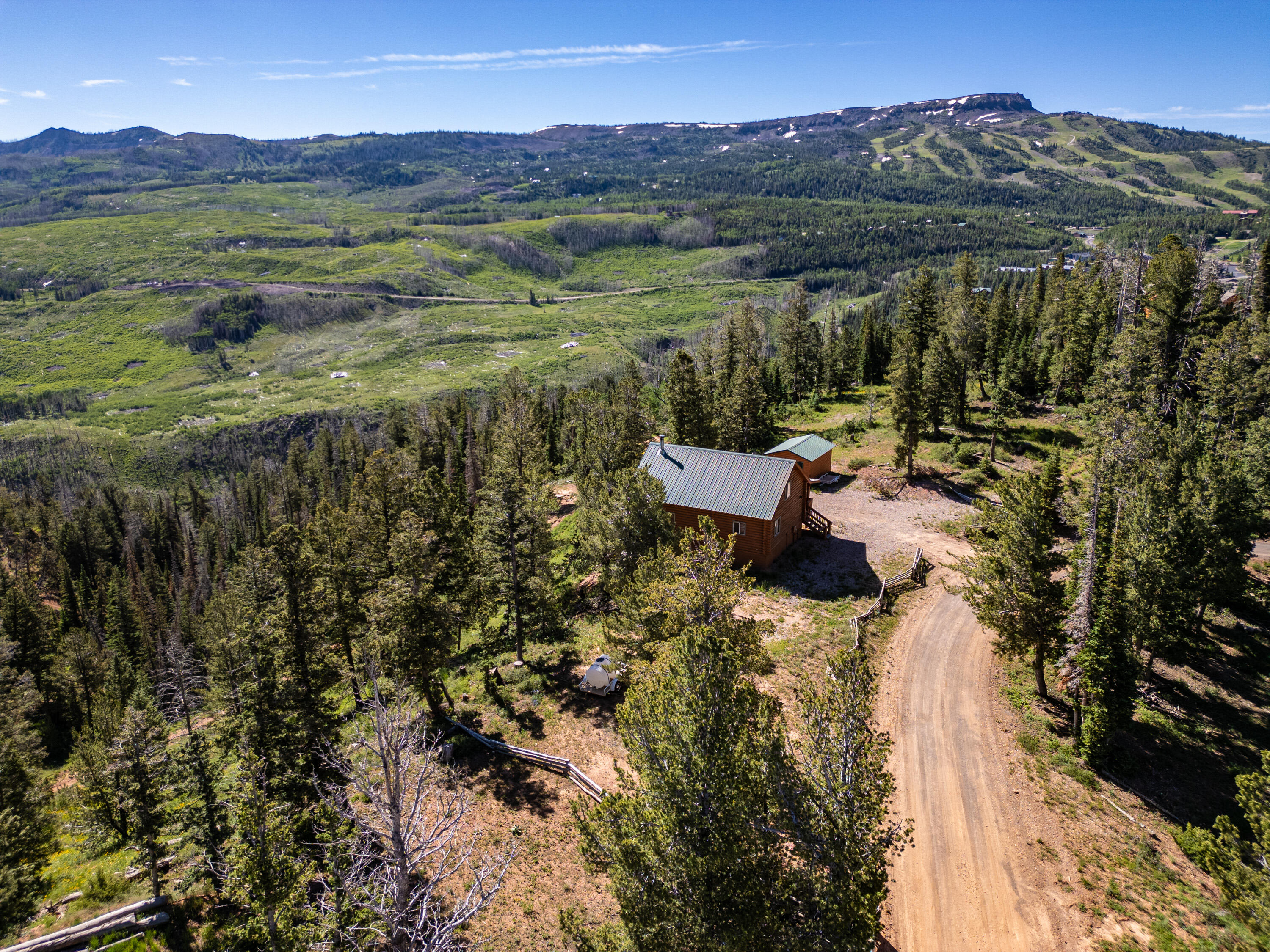 Discover breathtaking sunrises and sunsets from this beautiful log cabin in Brian Head. Located minutes away from Brian Head Resort. This meticulously crafted home features a wall of tinted windows in the living room and two spacious decks for enjoying views of the ski area, pink cliffs, and Tusher Mountain range. The kitchen boasts new granite countertops, modern appliances, and custom hickory cabinets. The main level includes a master suite with a remodeled shower and countertops. Upstairs offers a loft, an additional bedroom, and a bath, while downstairs features a large family room, another bedroom, laundry, and a water room with 1,500 gallons of storage. New toilets, a one-car garage, and an extra lot totaling 1.13 acres. Offered turn key for a seamless move-in!
