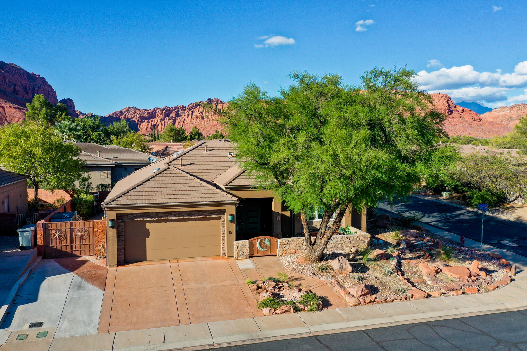 Situated near the breathtaking backdrop of the majestic Red Mountains in the desirable Copper Canyon community. Thoughtfully designed with an open, natural light filled floor plan. The home features numerous updates throughout. The kitchen showcases rich wood cabinetry, sleek granite countertops, large center island with stone detail and stainless appliances. The living room is anchored by a stunning fireplace and large windows framed for capturing mountain views. The primary suite includes a spa inspired ensuite bathroom with an oversized walk in shower and custom tile surrounds. Additional guest bathroom is equally impressive with modern updates. Outside the low maintenance desert landscaping complements the natural surroundings while the large covered patio provides a great space for entertaining. Located in a desirable community close to Snow Canyon State Park, this home offers refined living in one of Southern Utah's most scenic settings.
