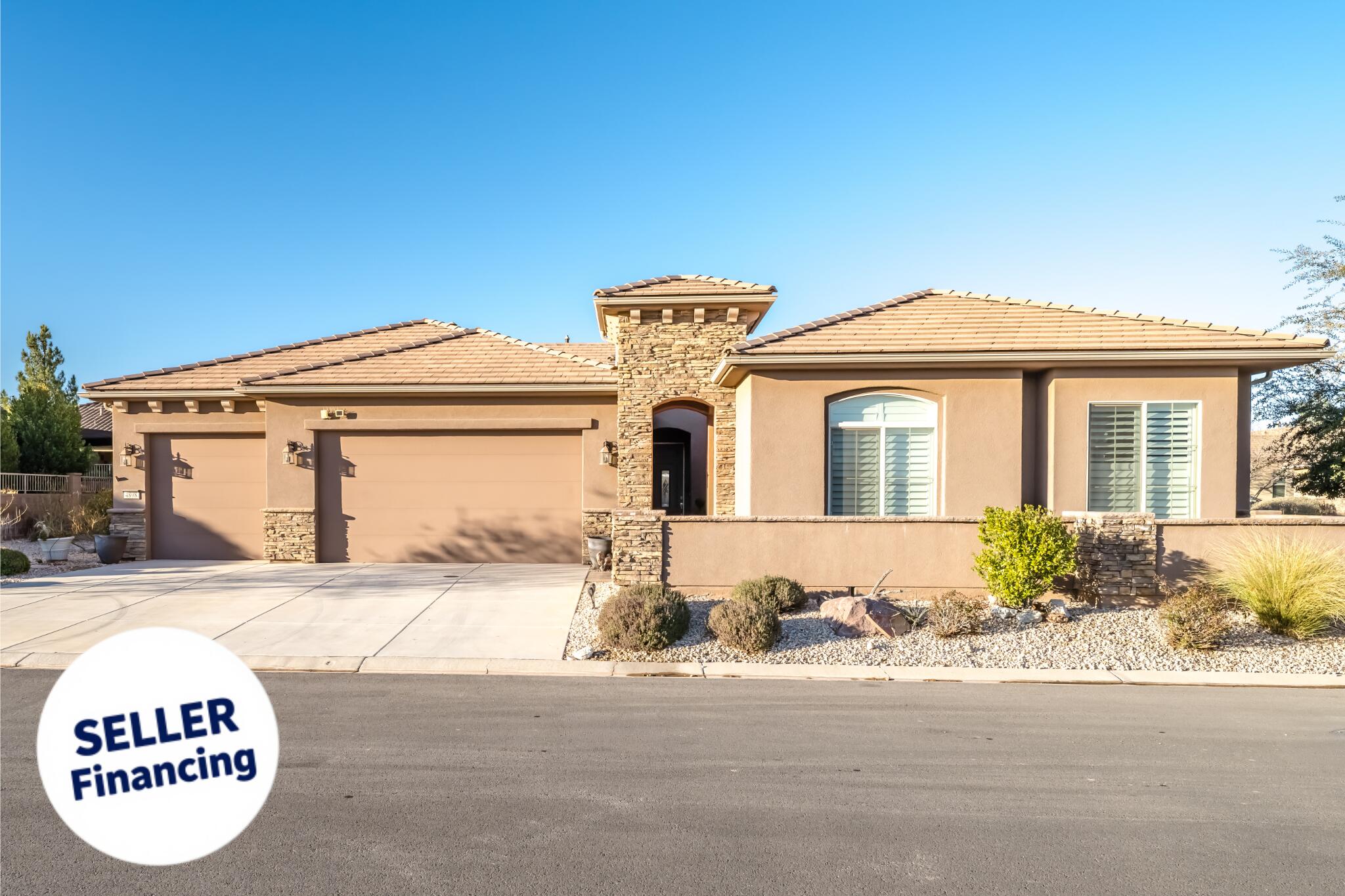 SELLER FINANCING AVAILABLE! Rare original-owner SunRiver retreat featuring a true 769 sq ft attached ADU, oversized 4-car garage, and dual primary suites, a combination almost impossible to find in Utah's premier 55+ community. Perfectly positioned on a private corner lot with no neighbors across the street and stunning red rock views, this 2015 single-level home offers 2,370 sq ft in the main residence (3 bedrooms, 2.5 baths) plus a fully attached 1BR/1BA guest suite with kitchenette and separate access - ideal for visiting family, a live-in companion, or seasonal guests. Inside you'll find vaulted ceilings, a custom-fitted dressing room creating an unmatched secondary owner's suite, dedicated den/office, formal dining room, wet bar, gas fireplace, skylight, and a chef's kitchen with built-in oven, range hood, and walk-in pantry storage. The covered patio and beautifully landscaped front courtyard extend the living space outdoors year-round. Step outside your door to championship golf, pickleball, indoor and outdoor pools, hot tub, fitness center, tennis, putting greens, and the celebrated SunRiver clubhouse -- all included with full-yard maintenance in the HOA. Just minutes to Sand Hollow, Quail Creek, and the gateway to Zion National Park. Snowbirds, full-time retirees, and multi-generational buyers -- this is the SunRiver home you've been waiting for.