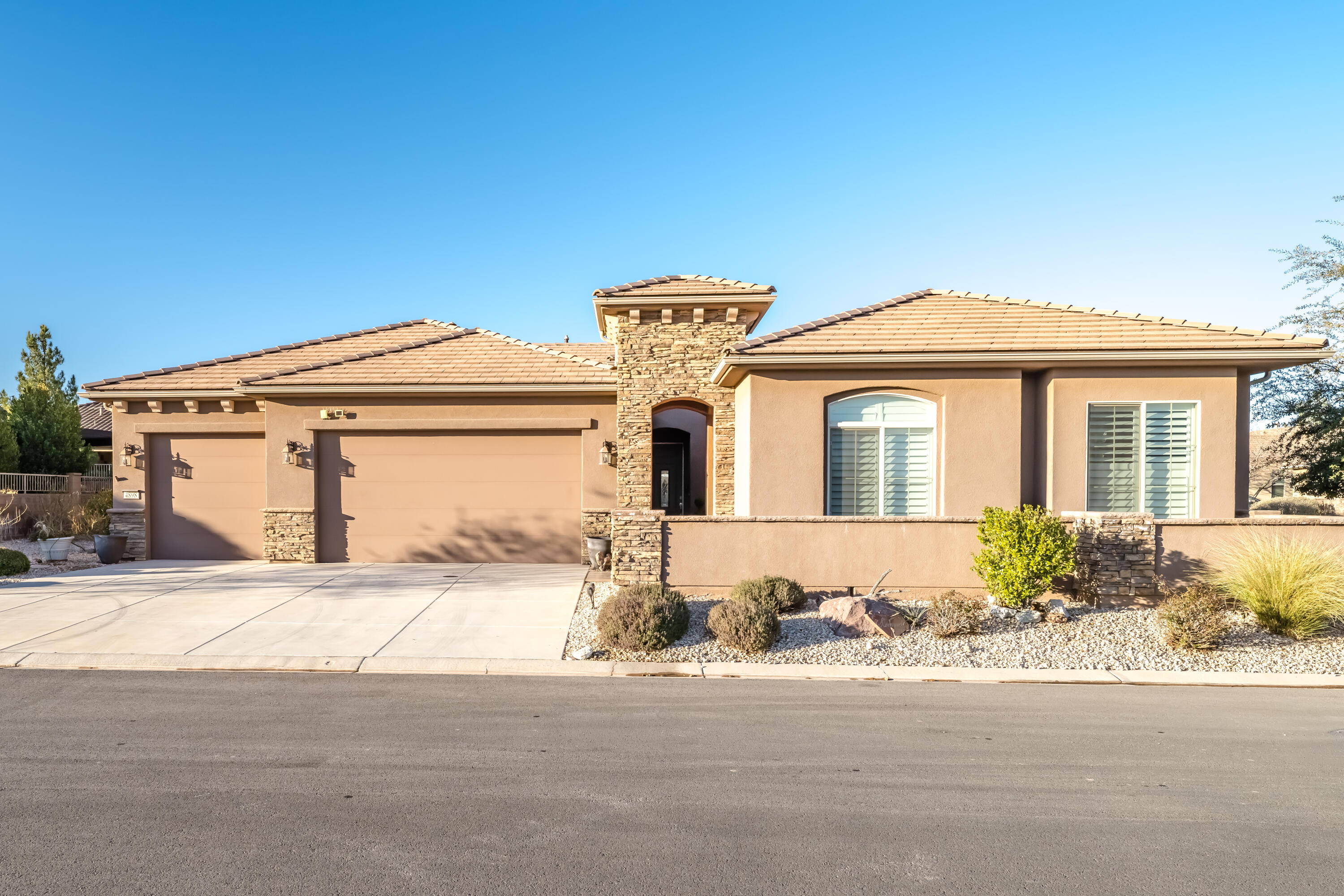 Rare original-owner SunRiver retreat featuring a true 769 sq ft attached ADU, oversized 4-car garage, and dual primary suites, a combination almost impossible to find in Utah's premier 55+ community. Perfectly positioned on a private corner lot with no neighbors across the street and stunning red rock views, this 2015 single-level home offers 2,370 sq ft in the main residence (3 bedrooms, 2.5 baths) plus a fully attached 1BR/1BA guest suite with kitchenette and separate access - ideal for visiting family, a live-in companion, or seasonal guests. Inside you'll find vaulted ceilings, a custom-fitted dressing room creating an unmatched secondary owner's suite, dedicated den/office, formal dining room, wet bar, gas fireplace, skylight, and a chef's kitchen with built-in oven, range hood, and walk-in pantry storage. The covered patio and beautifully landscaped front courtyard extend the living space outdoors year-round. Step outside your door to championship golf, pickleball, indoor and outdoor pools, hot tub, fitness center, tennis, putting greens, and the celebrated SunRiver clubhouse -- all included with full-yard maintenance in the HOA. Just minutes to Sand Hollow, Quail Creek, and the gateway to Zion National Park. Snowbirds, full-time retirees, and multi-generational buyers -- this is the SunRiver home you've been waiting for.