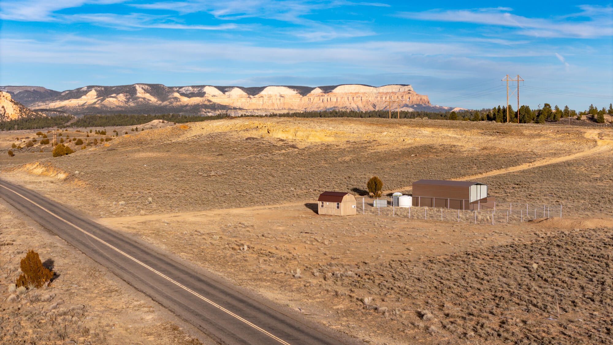 Exceptional opportunity to acquire 68 acres located just off Highway 12 and John's Valley Road. This highly visible property sits within Southern Utah's active tourism corridor and offers convenient access to the area's major national parks, along with nearby hiking, ATV trails, and year-round recreation.  Currently zoned Agricultural, the property presents strong future development potential, including the possibility of rezoning to Commercial through planning and zoning. The acreage borders Bryce Canyon City and may be eligible for annexation into city limits, further expanding potential development opportunities. With similar commercial properties already established along Highway 12, this parcel is well suited for a variety of uses, including a hotel, lodge, RV park, or tiny cabin development. The land also includes multiple functional outbuildings that support agricultural and operational use. Improvements include a metal-covered equipment/storage structure, a wood-sided shed with windows, and additional utility structures, all situated within a fenced area for added organization and security. These features enhance the usability of the property and offer flexibility for continued agricultural use or future development planning. This is a rare opportunity to own a large, versatile parcel in one of Southern Utah's most desirable destination areas.
(Seller will carry note with $500k down.  Terms negotiable.)