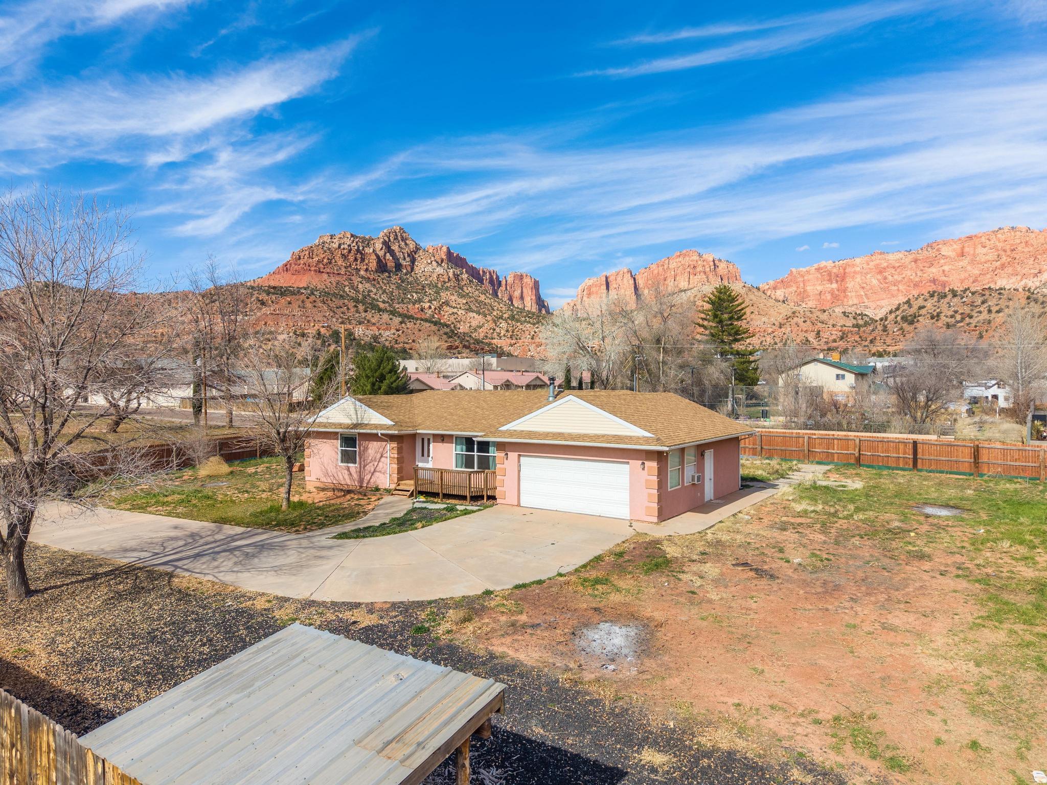 Welcome to this beautiful open floor plan home on over-half-acre corner lot with stunning Red Mountain views. Step into a cozy living room with a charming wood-burning stove, perfect for relaxing evenings. The kitchen has been refreshed with brand-new cabinetry and offers lots of storage, including a large walk-in pantry/storage room that could easily be converted into a third bedroom. Features 2 bedrooms and 2 bathrooms, with recent updates throughout including new flooring, new carpet, some fresh paint, and a remodeled primary bathroom. Enjoy outdoor living from the patio while taking in the scenic views, plus the convenience of RV parking with hookups. Located near hiking, biking, and ATV trails, next door to a coming-soon community park, and close to schools, this property is ideal as a starter home, investment opportunity, or peaceful retreat with room to grow.