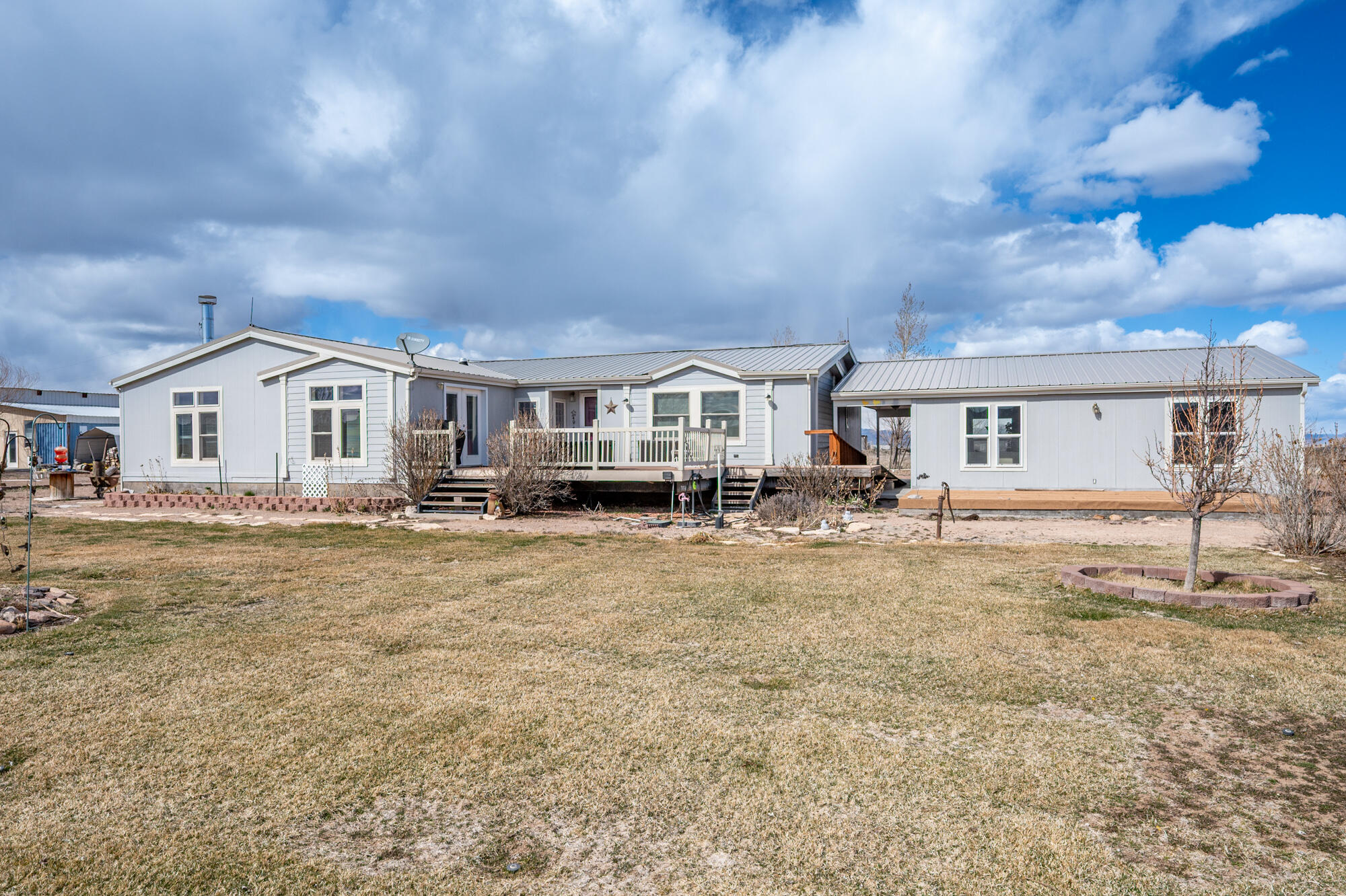 Perfect mini ranch at the end of a quiet street on a peaceful 10-acre parcel with beautiful views in every direction! This 2,300 sq ft single-level home offers 3 bedrooms, 2 bathrooms, a spacious country kitchen with center island, and a large primary suite. Enjoy cozy evenings with both a real fireplace and a wood stove. The home also features a 2-car garage and a basement ideal for additional storage. Property includes a shared well with 2 acre-feet of water. Fully fenced and cross-fenced for horses with a sprinkler system in place. Three Connex boxes with cement roofs and garage doors provide excellent space for toys, hay storage, or a workshop. A perfect blend of comfort, functionality, and country living!