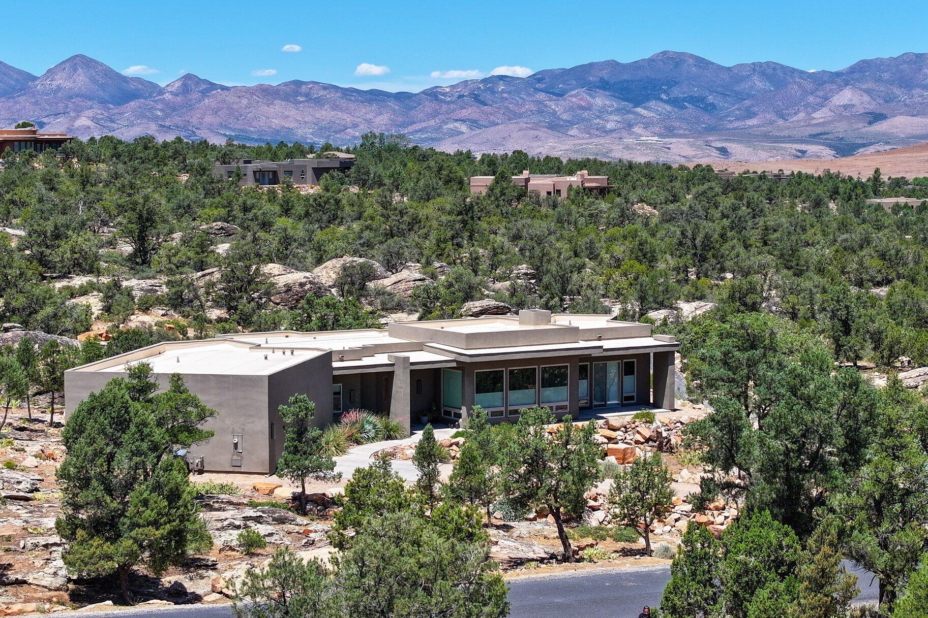 Welcome to Pinion Hills. Set on a full acre and built in 2016, this elevated home captures sweeping panoramic views and is surrounded by pinion trees whose fresh, earthy scent greets you on arrival. Conveniently located just 20 minutes north of St. George--where temperatures typically run about 10 degrees cooler--you'll enjoy a more comfortable climate without sacrificing access to town.

Inside, the home offers 3 bedrooms and 2 bathrooms, with one currently used as an art studio--ideal for creative space or a quiet office. Concrete floors run throughout, providing a clean, modern look with easy upkeep, while large windows fill the home with natural light and keep the views front and center.

An oversized garage adds flexibility for storage, hobbies, or outdoor gear. Low-maintenance and thoughtfully positioned, this property offers space, privacy, and a setting that feels calm, open, and distinctly Southern Utah.
