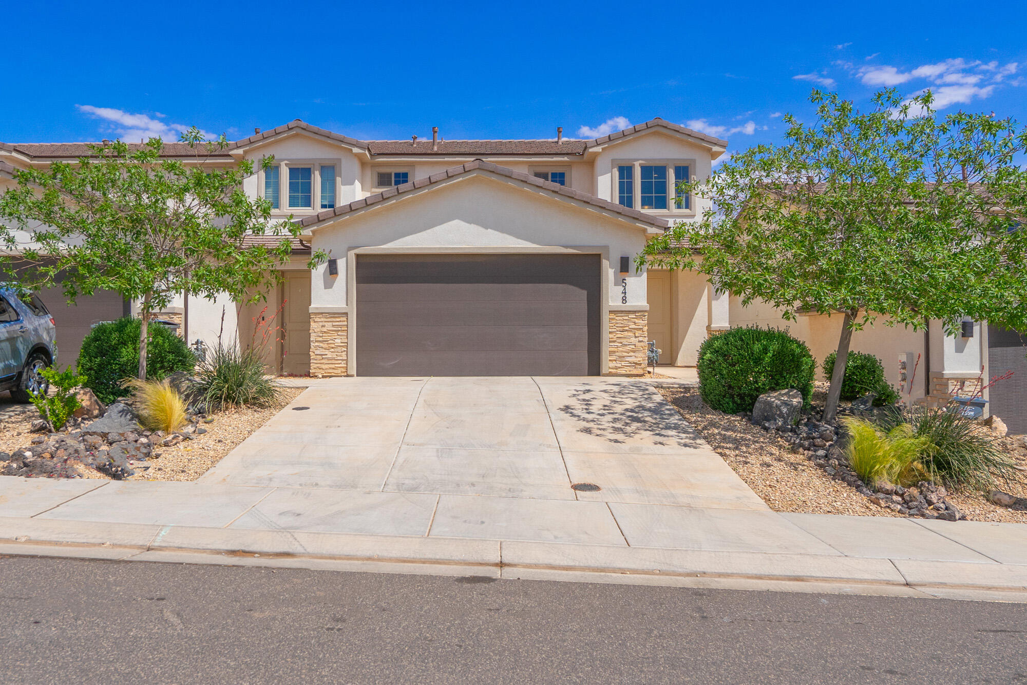 End-unit townhome with main-level master suite & stunning Hurricane Valley views! Features custom cabinets, quartz countertops, modern hard-surface flooring, tiled tub/shower surrounds, adult-height counters, upgraded railings, oversized garage, and high-quality finish carpentry. Community amenities include pickleball, basketball court, and play area. A perfect blend of style, comfort, and views.