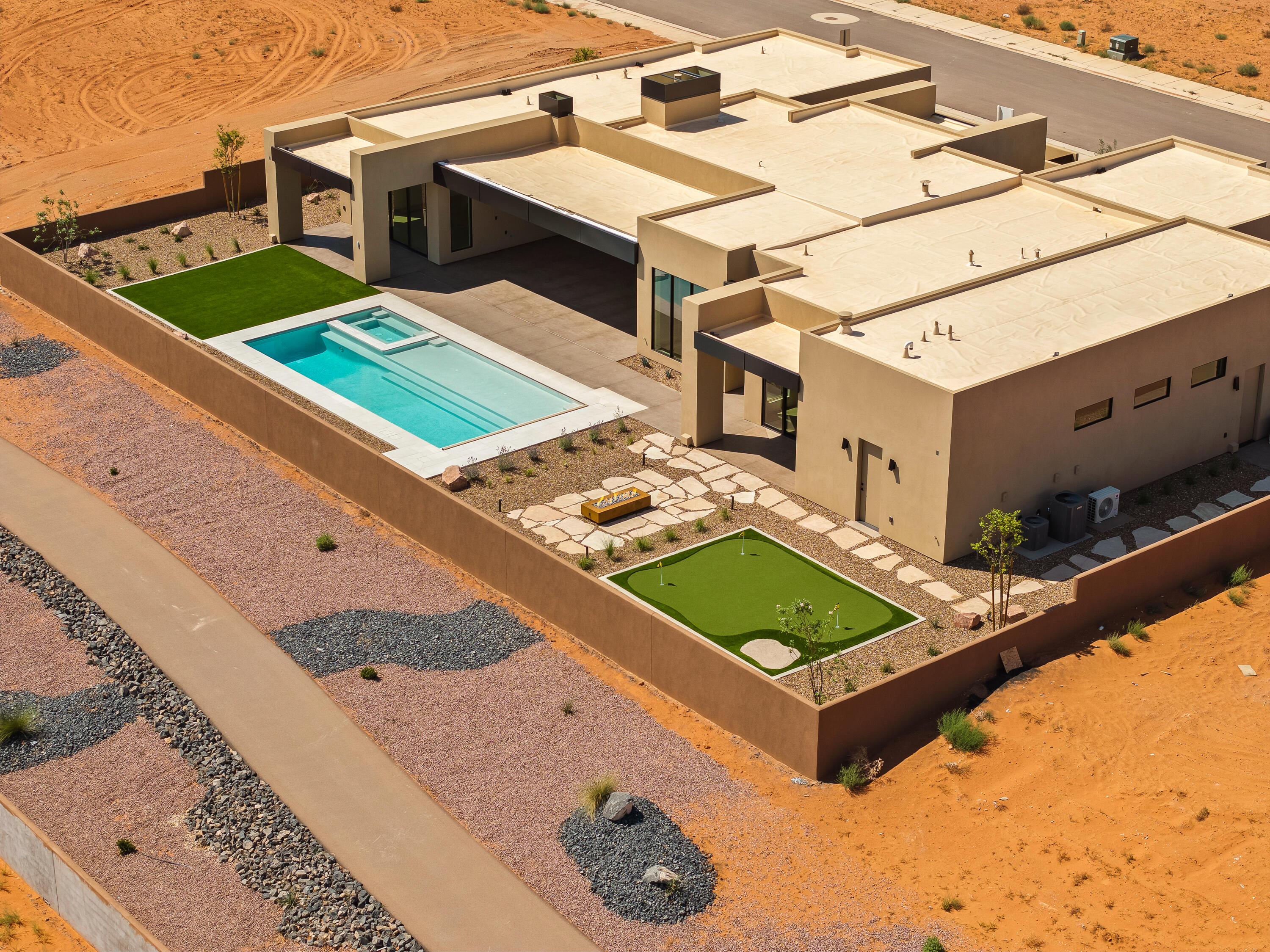 Brand-new 2025 modern desert masterpiece in Sand Hollow Estates with an Amangiri-inspired design and over 3,950 sq ft of luxurious living space. This 4-bedroom, 4.5-bath home blends minimalist styling with exceptional comfort and functionality.
Step through a gated courtyard with a custom water feature into a spacious open floor plan highlighted by expansive glass sliders and designer finishes throughout. The chef's kitchen features a professional Signature appliance package, a massive 11-foot island, Taj Mahal leathered countertops, and a full butler's pantry with wine fridge and storage.
Retreat to the primary suite with walls of glass, his-and-her vanities and toilets, a freestanding tub, oversized glass shower, and custom walk-in closet with washer/dryer. Each additional bedroom includes its own en-suite bath, with private entrances and courtyards for ultimate privacy. A flex room with beverage fridge and microwave offers versatility for guests or entertainment.
Seamless indoor-outdoor living defines this home, with nearly 1,000 sq ft of covered rear patio space, a pool and spa with automatic cover, fire pit, and mini golf with stunning east-facing orientation for year-round enjoyment.
Additional highlights include:
-38-ft boat garage plus oversized 2-car garage with epoxy flooring
-3-sided custom fireplace with textured plaster surround
-Designer tile and lighting throughout
-Energy-efficient construction with tankless water heaters, blown-in insulation, and Low-E glass windows
-Smart home pre-wire for security, audio, automatic shades, and more
The HOA fee includes full yard maintenance, access to 3 pools, 2 hot tubs, a fitness center, and 2 pickleball courts. Residents also enjoy live music events and annual community celebrations like the Car Show, Sky Fest (Hot Air Balloon Festival), and the Pioneer Day Celebration. Residents also receive discounts and VIP access to golf, events, and UTV and watercraft rentals.
Located minutes from Sand Hollow Reservoir and championship golf, this home offers unmatched luxury and lifestyle in the heart of Southern Utah.