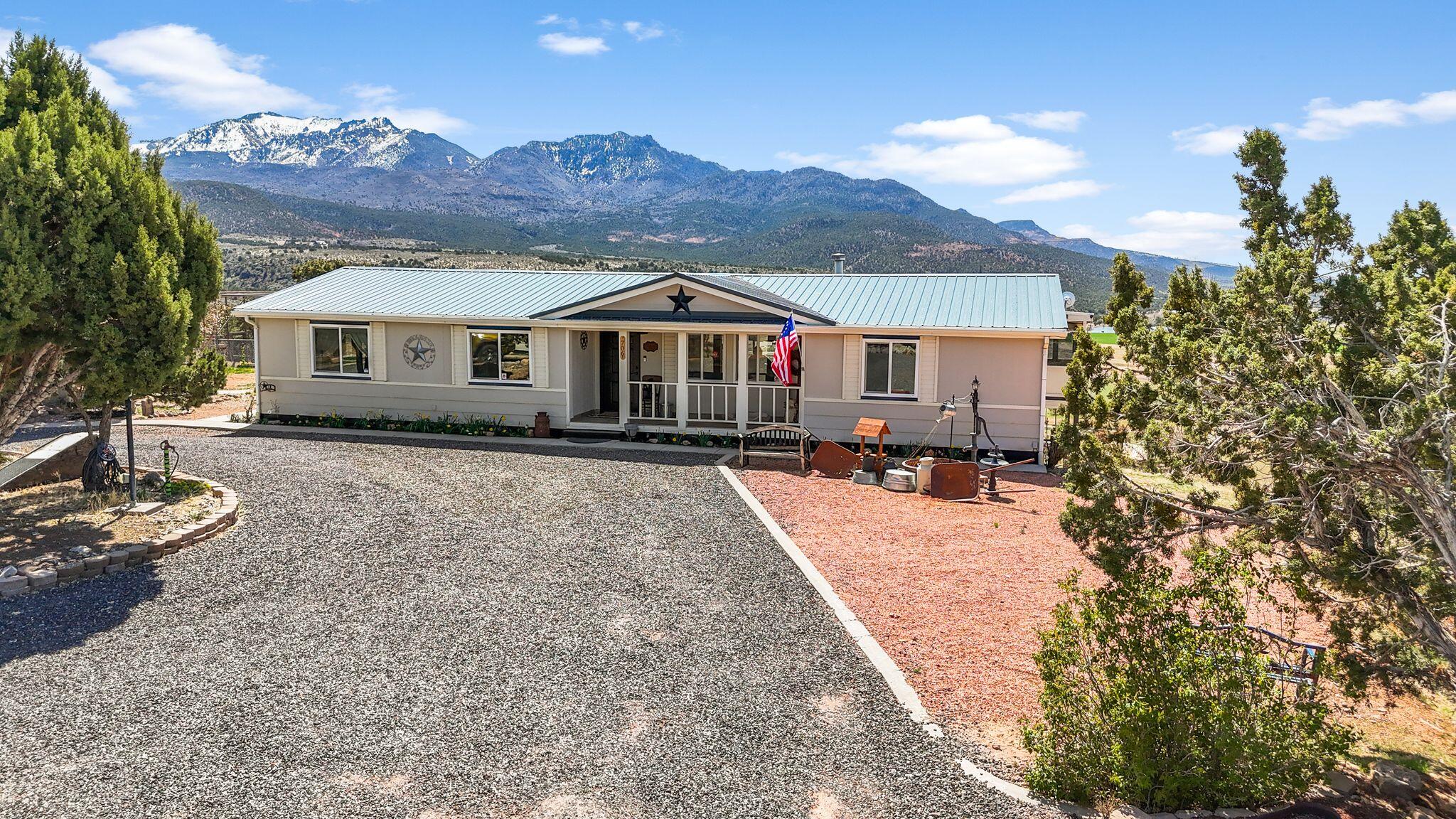 Beautifully Updated Home with Stunning Mountain Views! Don't miss this move-in-ready gem with spectacular views of Pine Valley Mountains! 1.32 acres. This thoughtfully updated home features a new roof, new windows, new flooring, and a new furnace with heat pump for year-round comfort. Cozy up next to the new pellet stove or cook in the refreshed kitchen with brand-new cabinets. Both bathrooms have been tastefully upgraded, offering modern style and convenience. Outside, enjoy an abundance of space with a 2-car garage, detached shop, and a separate RV garage—perfect for all your vehicles, projects, and storage needs.The landscaped yard includes mature pear, peach, and apricot trees, creating your own private orchard oasis. This home combines comfort, function, and unbeatable views.