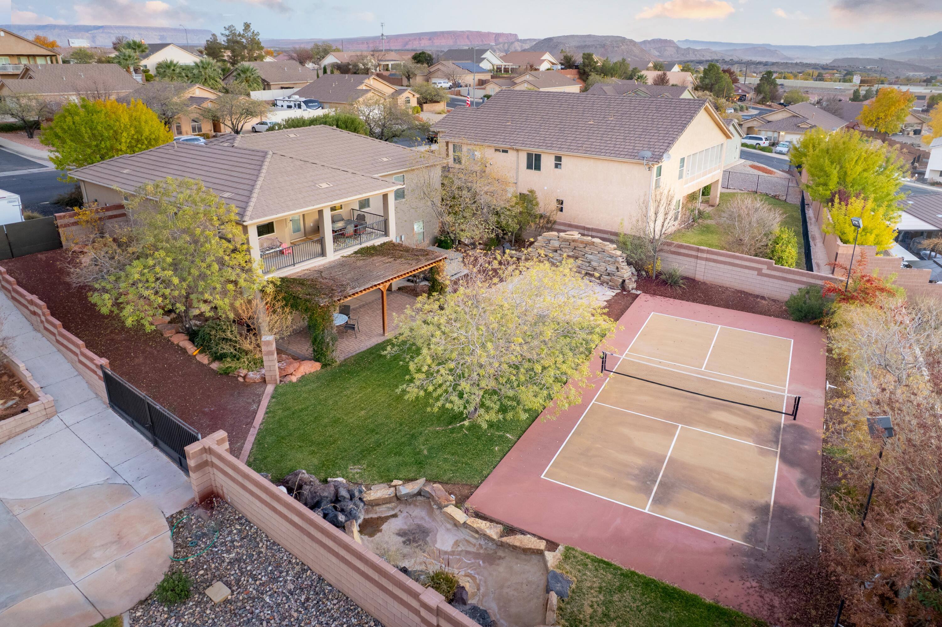 This Warm Springs home was designed for space, fun, and flexibility, sitting on a .28-acre lot with a backyard that's hard to find in town. Enjoy your own private pickleball court, splash pad, hot tub, pergola-covered patio, and water feature, creating a backyard setup that's perfect for entertaining and everyday enjoyment.

Inside, the 2,921 sq ft layout includes 6 bedrooms and 3 bathrooms, offering plenty of room for guests, hobbies, or multi-generational living. The main level features vaulted ceilings in the family room and primary suite, along with a kitchen equipped with granite counters, stainless appliances, and a gas range.

The walk-out basement adds additional living space with a large second family room and direct access to the backyard. Valley views from the upper deck and shaded patio below make it easy to enjoy Southern Utah's outdoor lifestyle.

Located close to I-15 and Washington City shopping, the home combines space, location, and a backyard that truly stands out.