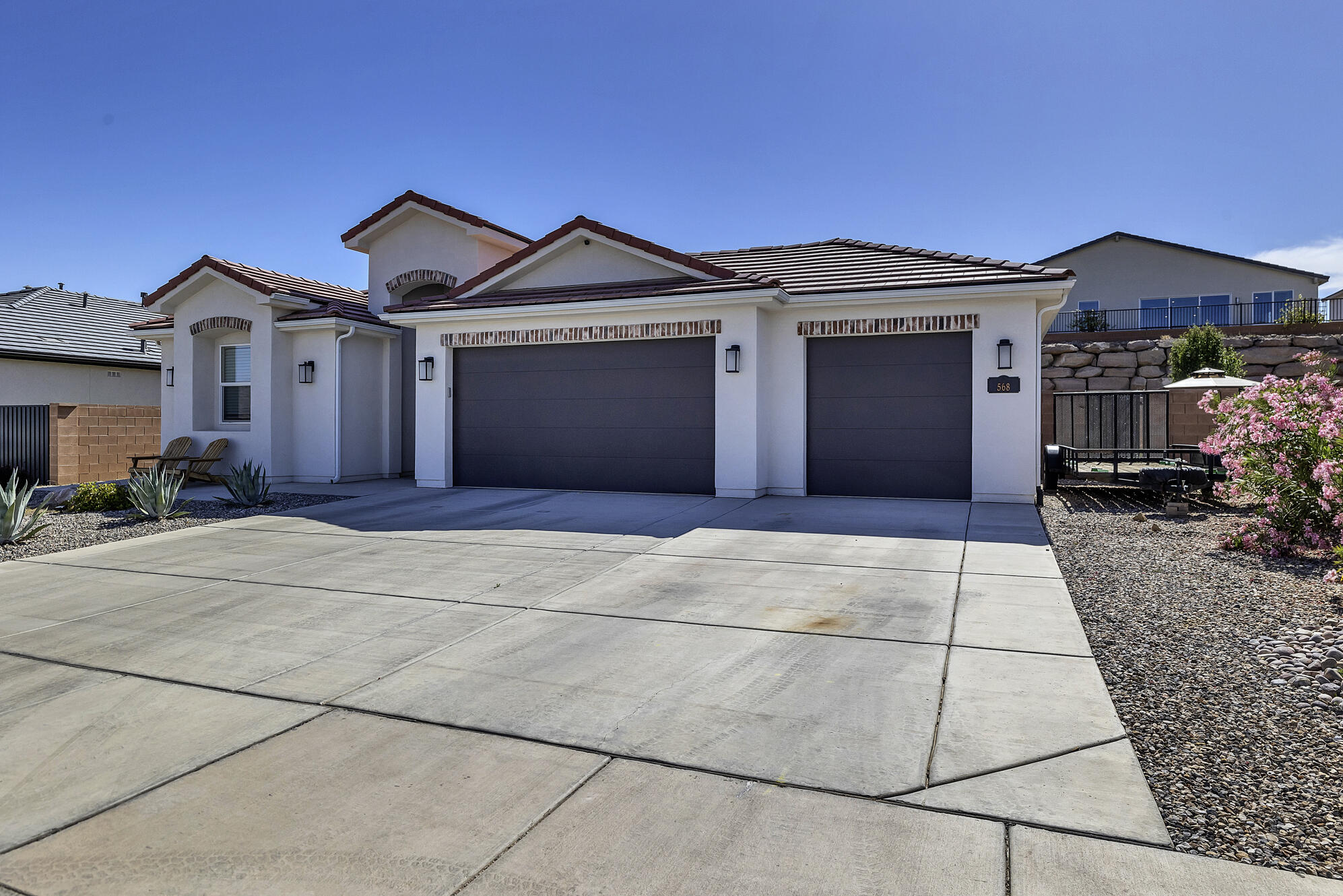 Located in the growing Divario area of St. George, this meticulously maintained home offers the comfort of newer construction with the ease of modern Southern Utah living. Built in 2023, this 4-bedroom, 2-bath single-family home features approximately 1,797 square feet of thoughtfully designed living space on a generous, beautifully landscaped lot.

The home presents excellent curb appeal with clean stucco architecture, a tile roof, low-maintenance desert landscaping, and a desirable three-car garage. The side yard offers valuable additional space with room to park a trailer, adding practical flexibility for recreational gear, storage, or Southern Utah adventure needs.

Inside, the home features a convenient, livable layout designed for everyday comfort. The primary suite includes a spacious walk-in shower, creating a private retreat with a clean, modern feel. Additional bedrooms provide flexibility for guests, work-from-home needs, hobbies, or storage.

With newer construction, a functional single-level layout, three-car garage, trailer parking potential, and convenient access to St. George amenities, trails, parks, and Southern Utah recreation, this home is a standout opportunity in a desirable Washington County location.