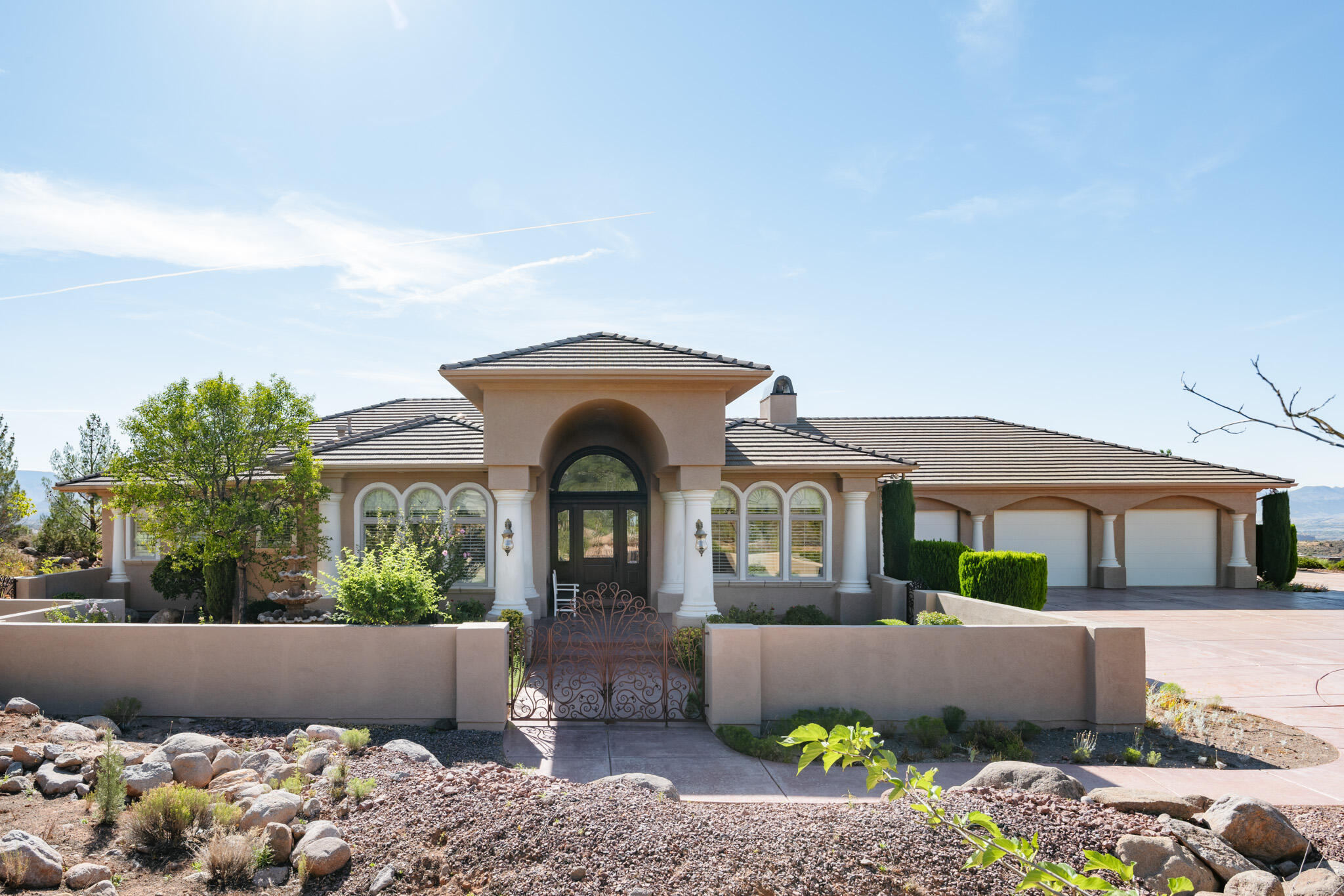 Perched on 1.73 acres in the prestigious Silver Reef area of Leeds, this exceptional custom estate captures breathtaking 360-degree views of Southern Utah's red rock landscape. Designed for both elegance and comfort, the home offers expansive indoor-outdoor living with two covered patios overlooking a private backyard.
Inside, rich cherry wood finishes, arched 8-foot doorways, backlit tray ceilings, and crystal chandeliers create a timeless, refined atmosphere. The thoughtfully designed floor plan provides full main-level living, with an additional complete living space in the basement -- ideal for guests, multi-generational living, or extended stays. The gourmet kitchens are appointed with marble and granite countertops, offering both beauty and functionality. The luxurious primary suite serves as a private retreat, featuring a newly updated spa-like bath with soaking tub, tile flooring, expansive walk-in closet, and steam shower. An oversized 5-car garage provides abundant storage and flexibility for vehicles, recreational toys, or workshop space. This is a rare opportunity to own a private estate with panoramic views, refined craftsmanship, and true Southern Utah serenity. Kitchen also has new counters upstairs with matching marble around the upstairs living room fireplace. Main living area has office and laundry room while the downstairs living area comes with gym, media room and separate laundry.