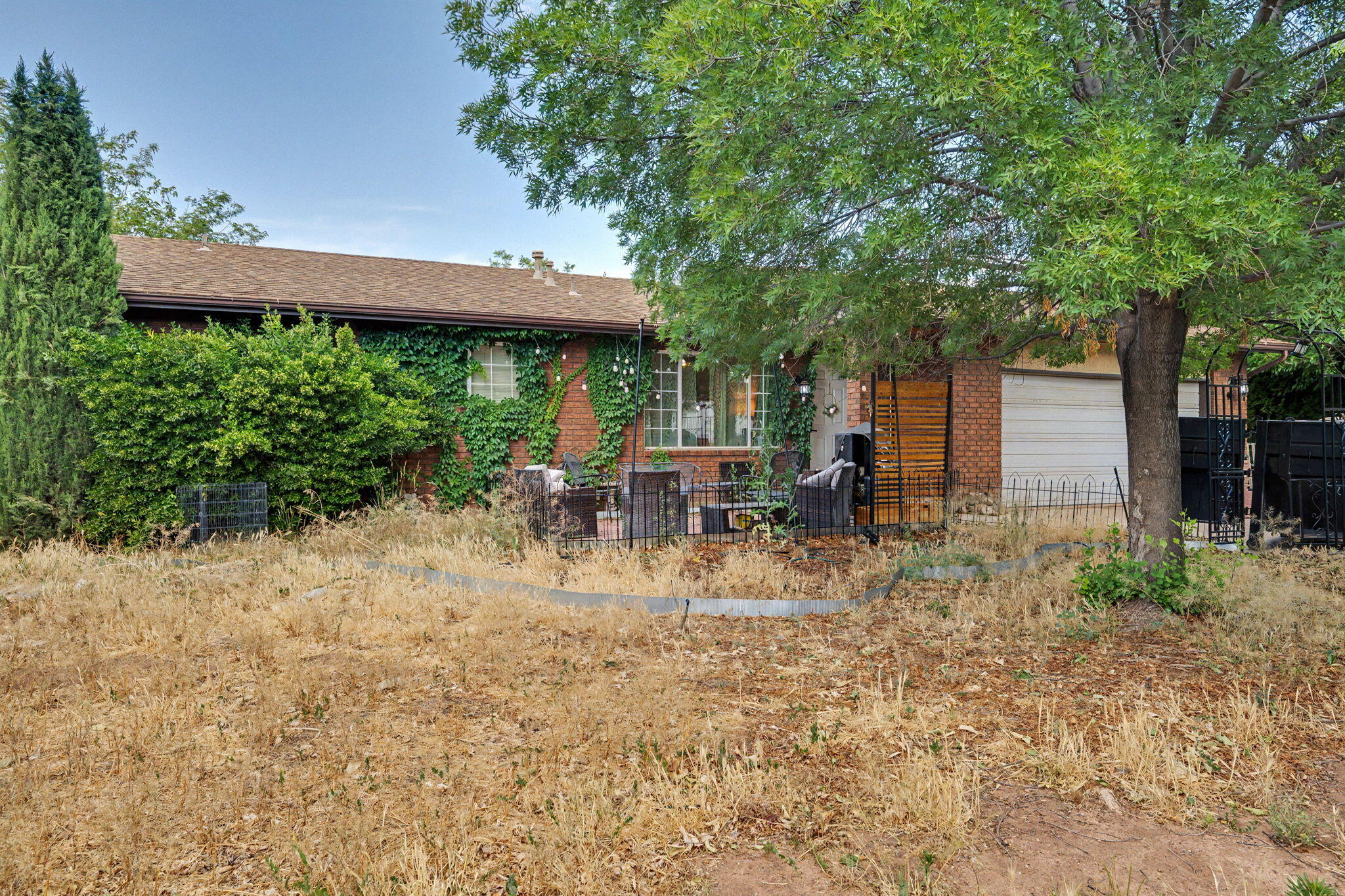 Single-family home in a quiet La Verkin neighborhood with no HOA and plenty of potential. The charming front patio is framed by mature ivy, lush trees, and string lights -- a welcoming outdoor space perfect for relaxing or entertaining. The home features a functional layout with a kitchen island, ceiling fans throughout, and a garage. The spacious backyard offers mature trees, room to landscape, and a canvas ready for your personal touch. Located just minutes from Hurricane, Zion National Park, and easy access to St. George. This is a great opportunity to own in a convenient Southern Utah location at an accessible price point.