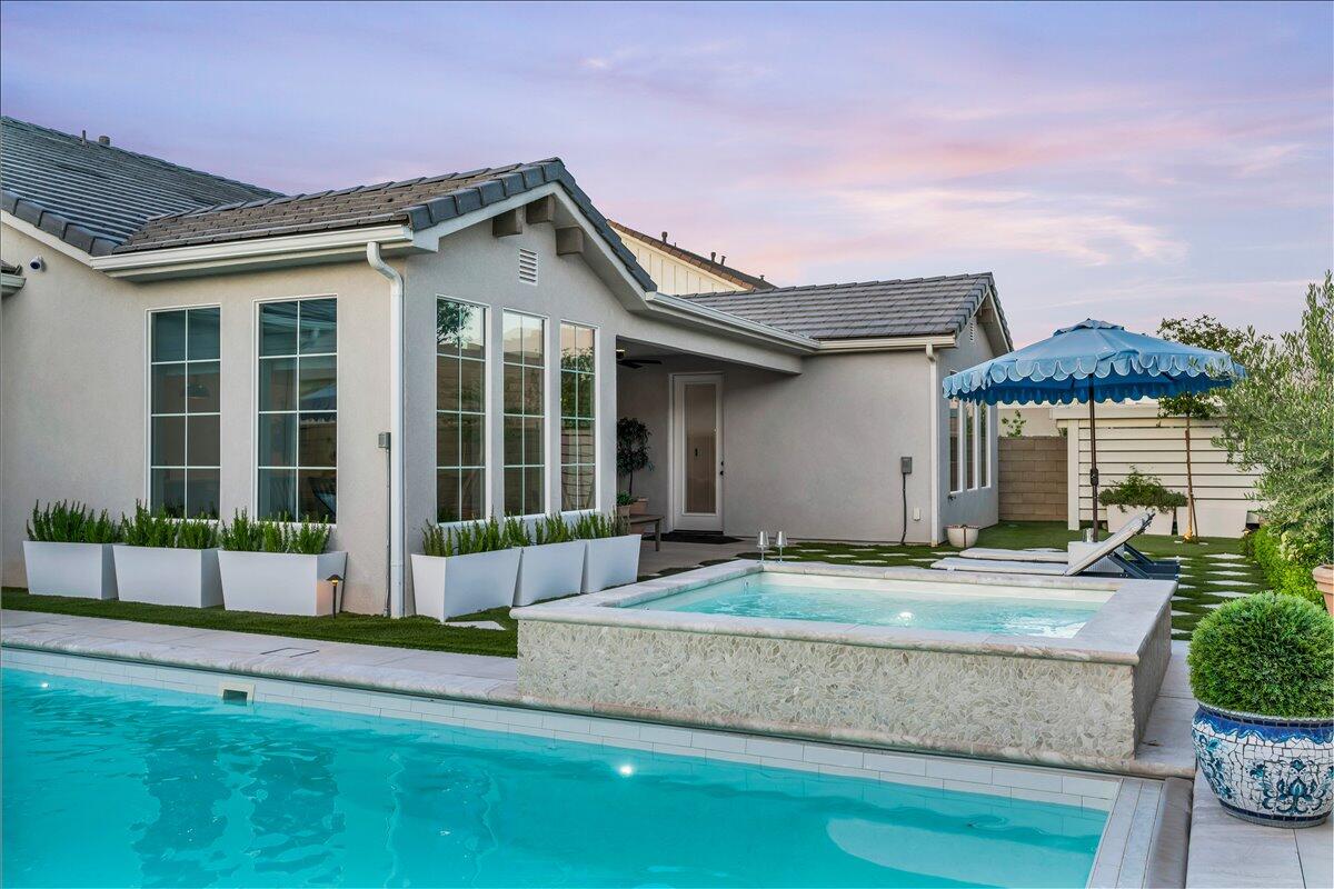 A truly elevated luxury residence centered around a private, resort-style pool and spa--blending timeless European elegance with modern sophistication, and offering a FULLY FURNISHED, turnkey experience designed for both comfort and style. Step outside to a backyard that immediately sets this home apart. The private heated pool and spa, completed in September 2024, showcases a waterfall feature, custom marble and tile surrounds, integrated lighting, Pentair equipment with active warranties, and an app-controlled automatic cover--creating a true resort-style experience. The outdoor space is fully dialed in with artificial turf, extensive tile work, privacy walls, and a large covered patio, while the front of the home offers stunning curb appeal with mature landscaping and a charming entry patio. Inside, you'll find an open-concept floor plan with elevated ceilings, quartz countertops, LVP flooring, and beautifully executed two-tone cabinetry. The home is filled with designer touches including accent walls, luxury wallpaper, an electric fireplace, and well-curated furnishings and décor--all included. Each bedroom features a walk-in closet, complemented by window tinting and treatments throughout, along with smart home features for added convenience. The European design influence draws from Italy, France, and Croatia, creating a refined and cohesive aesthetic. Additional features include HOA gated RV parking, an oversized 3-car garage, a water filtration system, and a full Ubiquiti security system. Homes of this caliber--offering this level of finish, functionality, and outdoor experience--are few and far between. Buyer/buyers agent to verify all information.